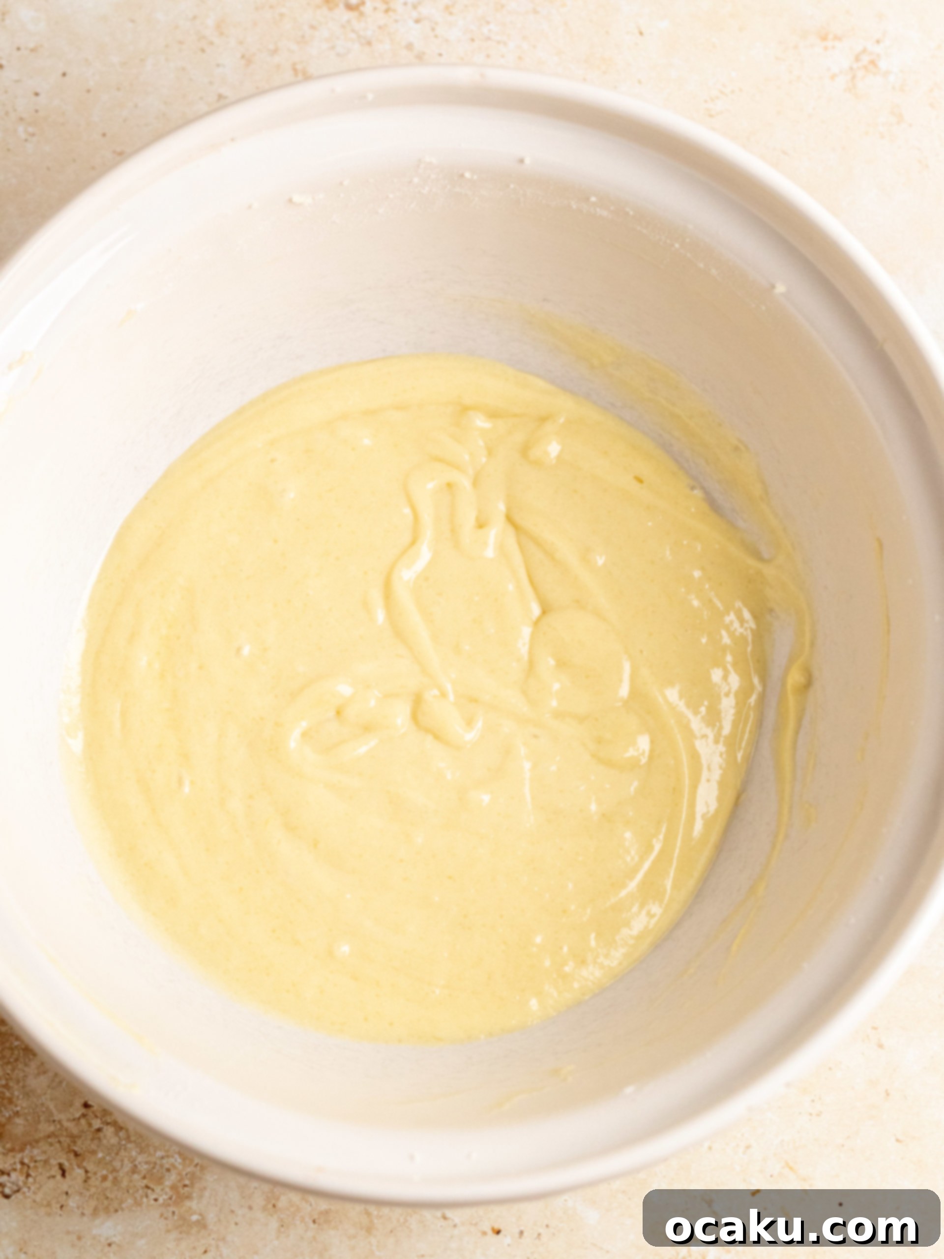 Cupcake batter being mixed in a stand mixer.