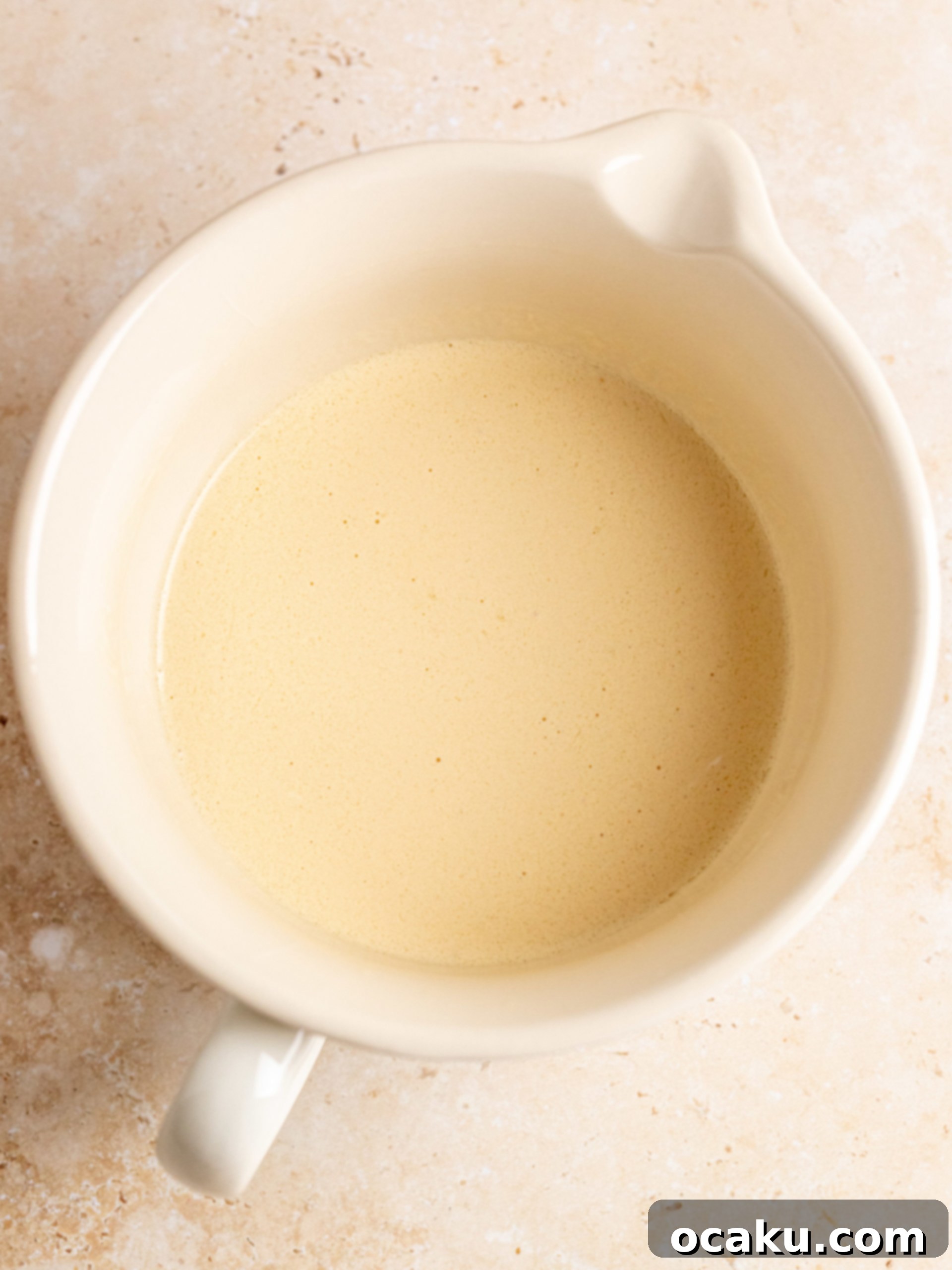 Step-by-step image showing butter being creamed in a stand mixer.