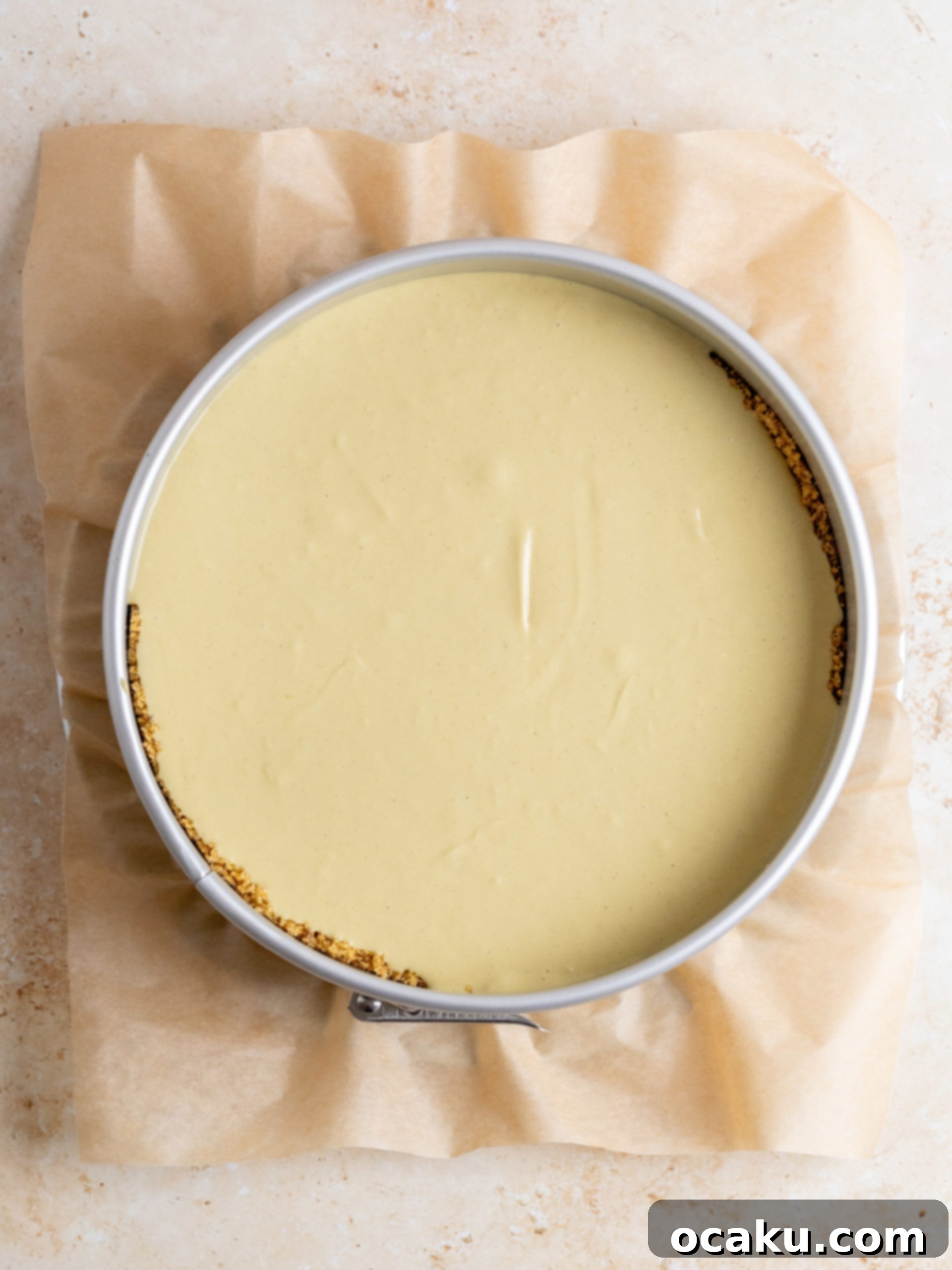 Pistachio cheesecake filling being poured into the crust