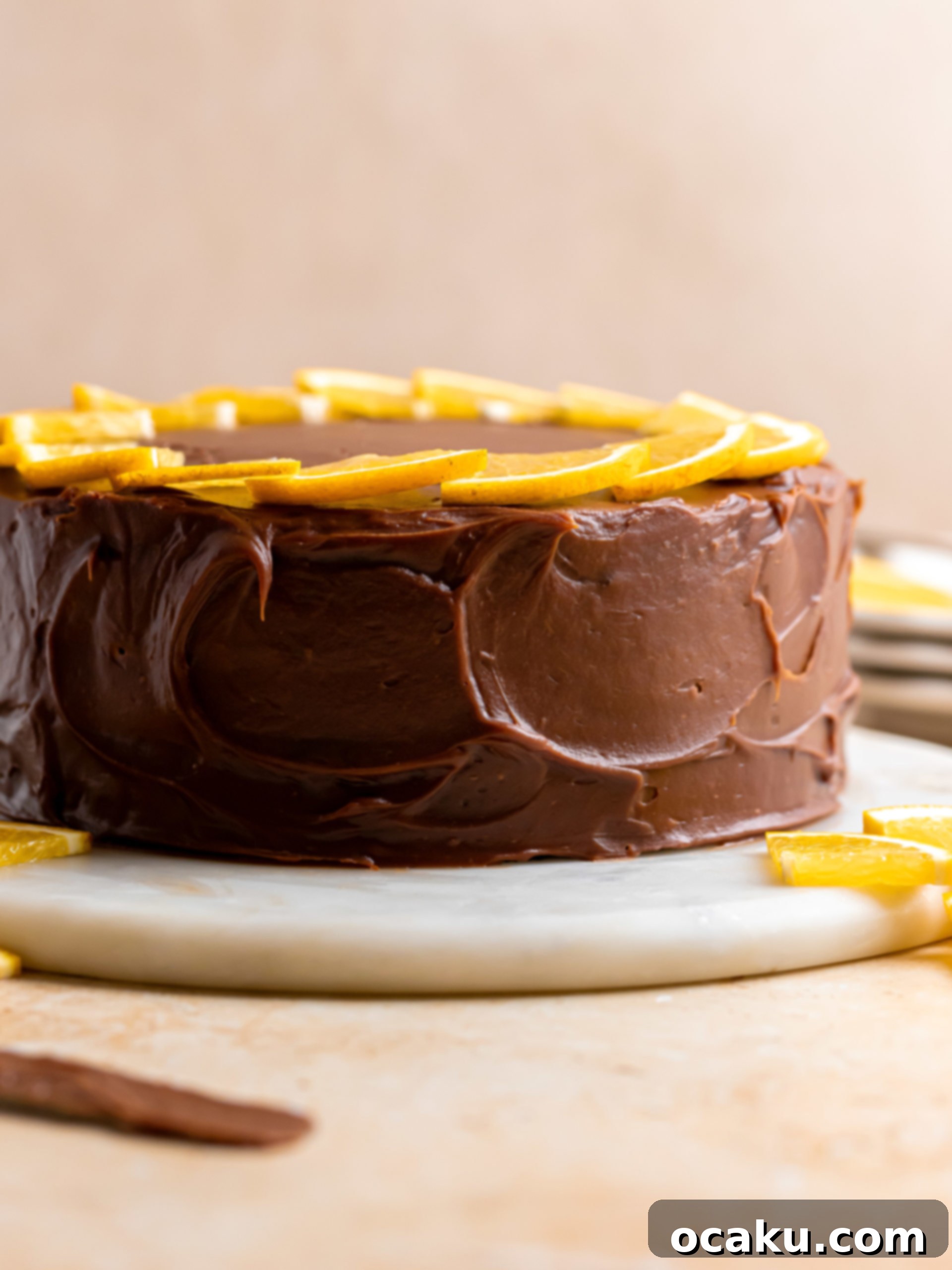 A slice of chocolate orange cake on a plate, showcasing the layers and creamy ganache.