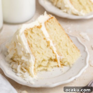 Ultimate Coconut Cloud Cake 10 Coconut cake with cream cheese frosting and toasted coconut flakes