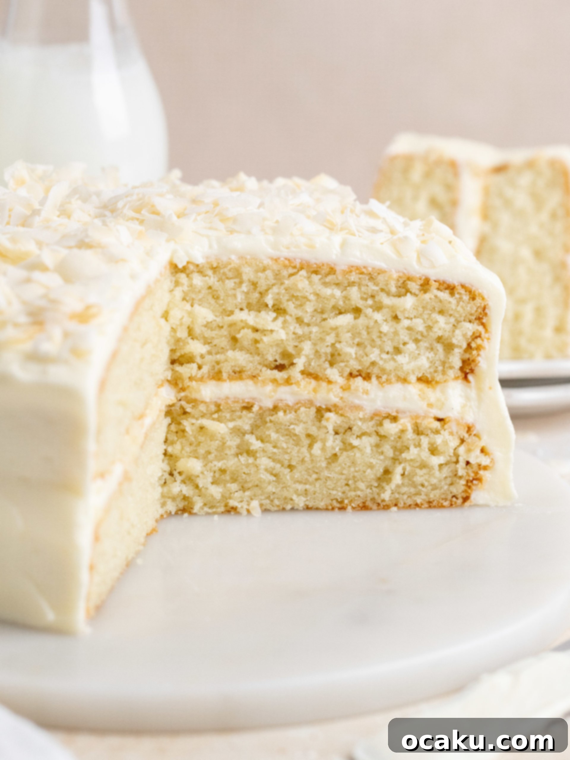 Ultimate Coconut Cloud Cake 8 Beautifully decorated coconut cake on a stand