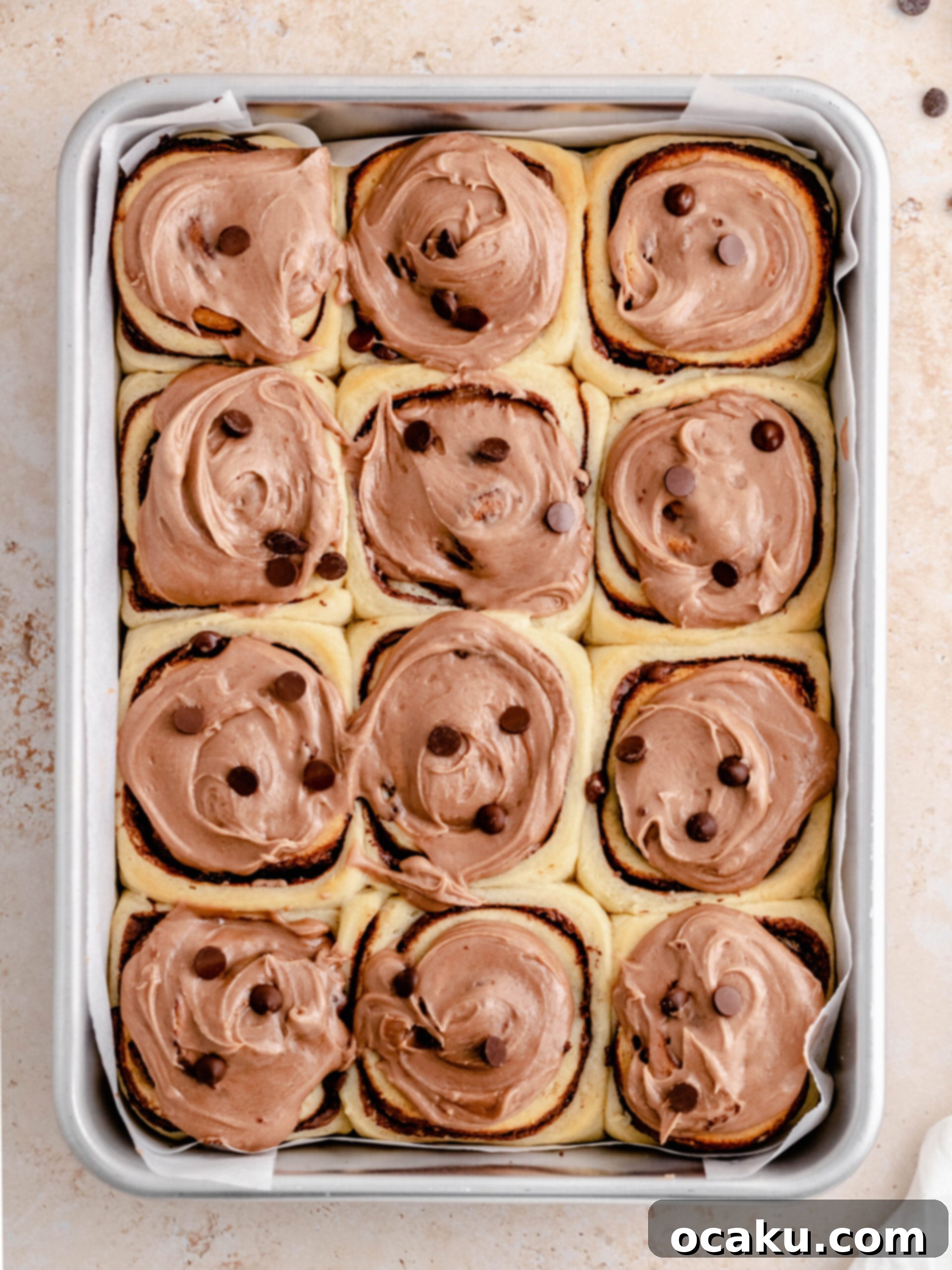 Decadent Nutella Swirls 2 Freshly baked Nutella rolls cooling in a baking pan, showcasing their golden-brown tops and rich filling.