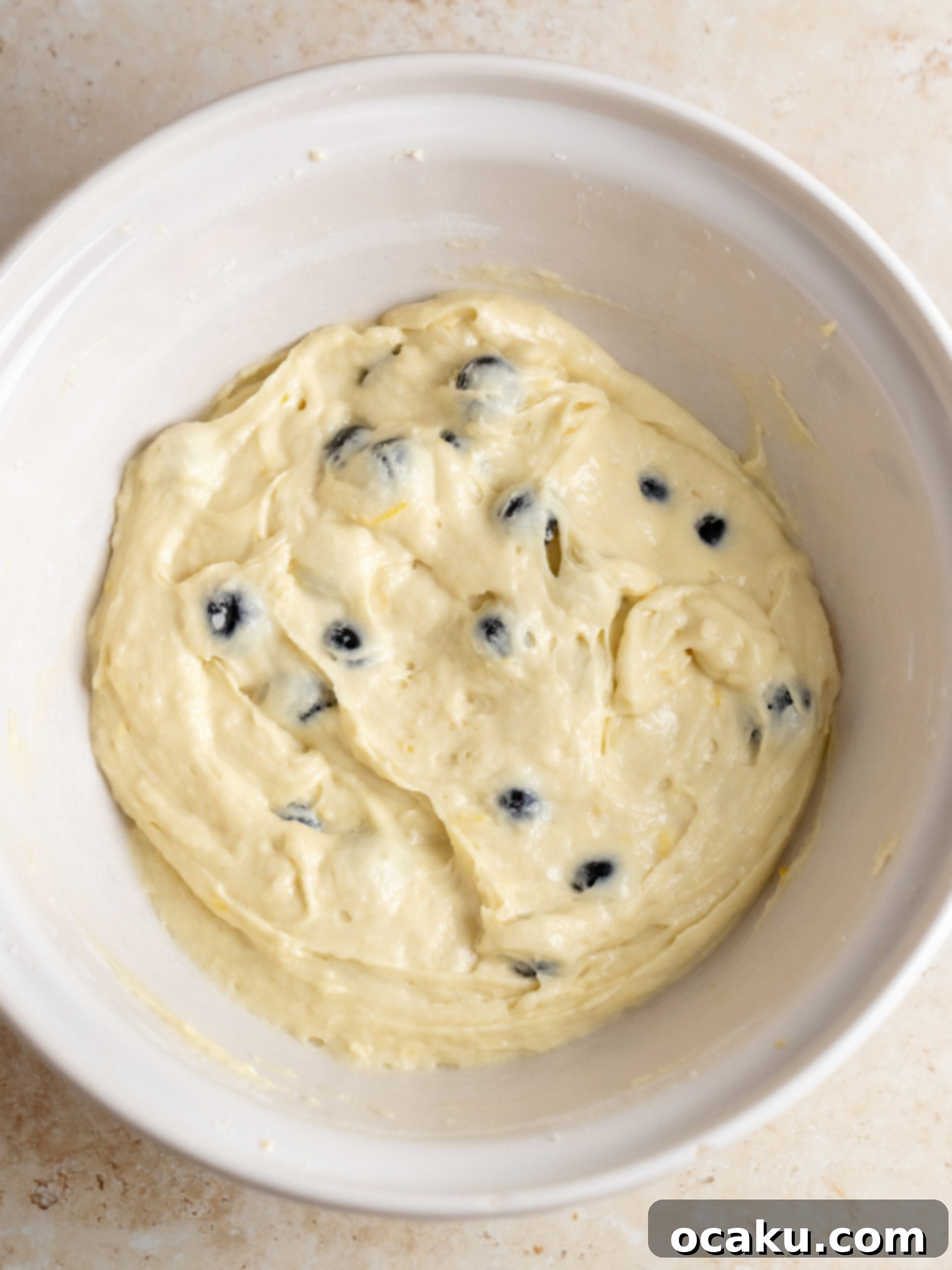 Butter and sugar being creamed together in a stand mixer, forming a light and fluffy mixture.