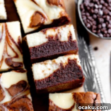 A delicious slice of fudgy cheesecake chocolate brownie with a creamy swirl.