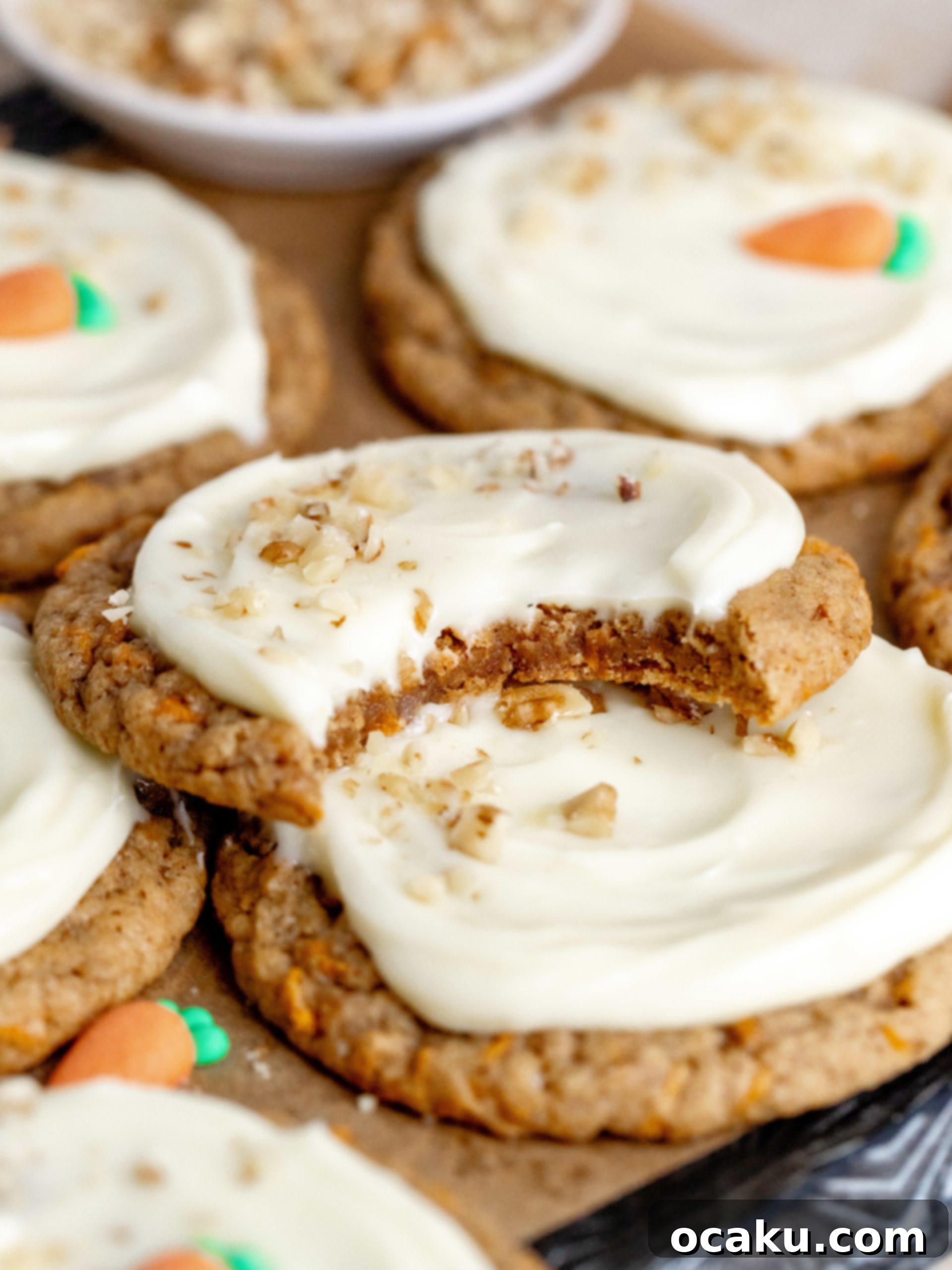 Close-up of a frosted carrot cake cookie with visible grated carrots and walnuts.