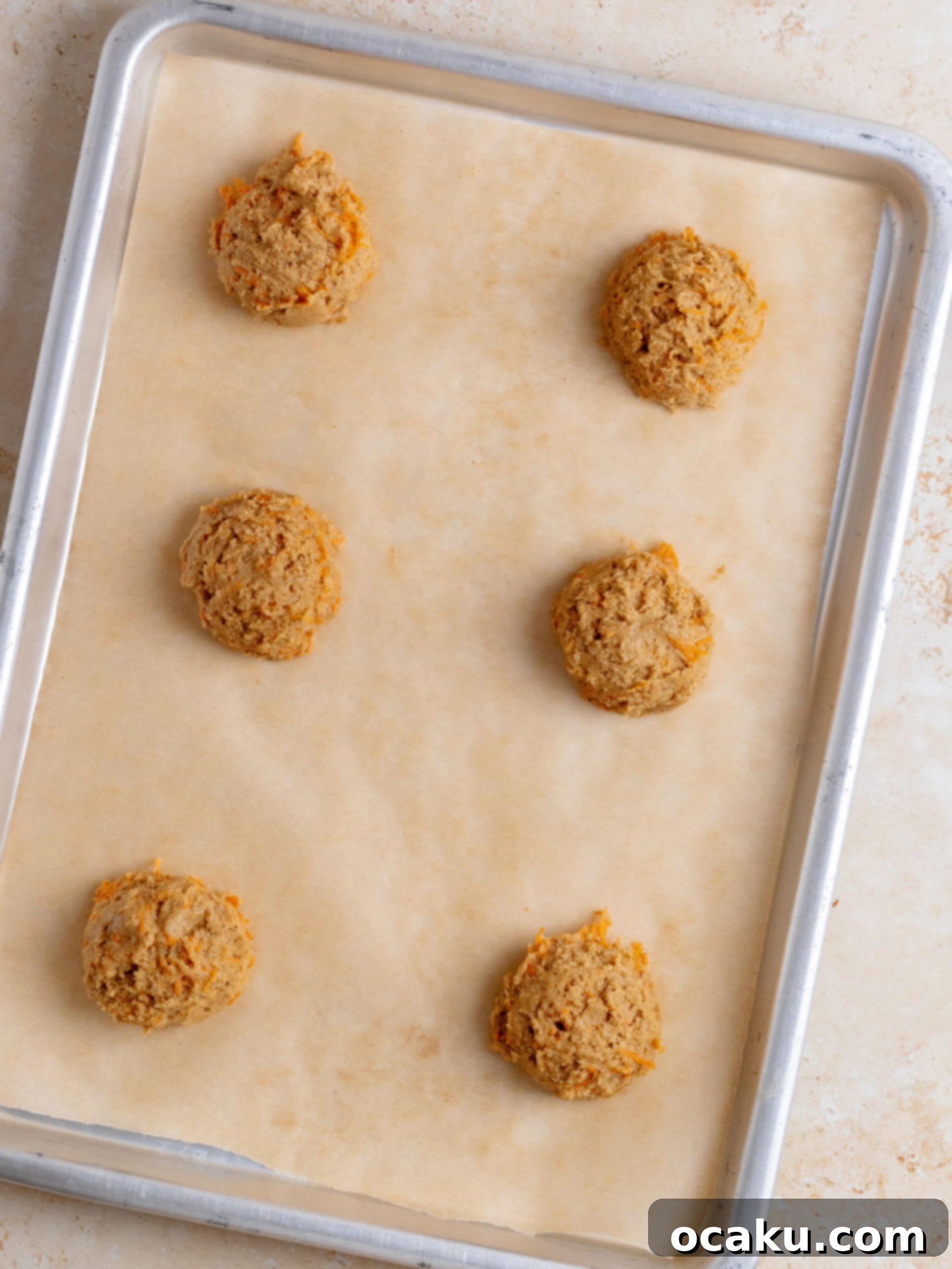 Image showing shredded carrots being mixed into the wet ingredients for cookies.