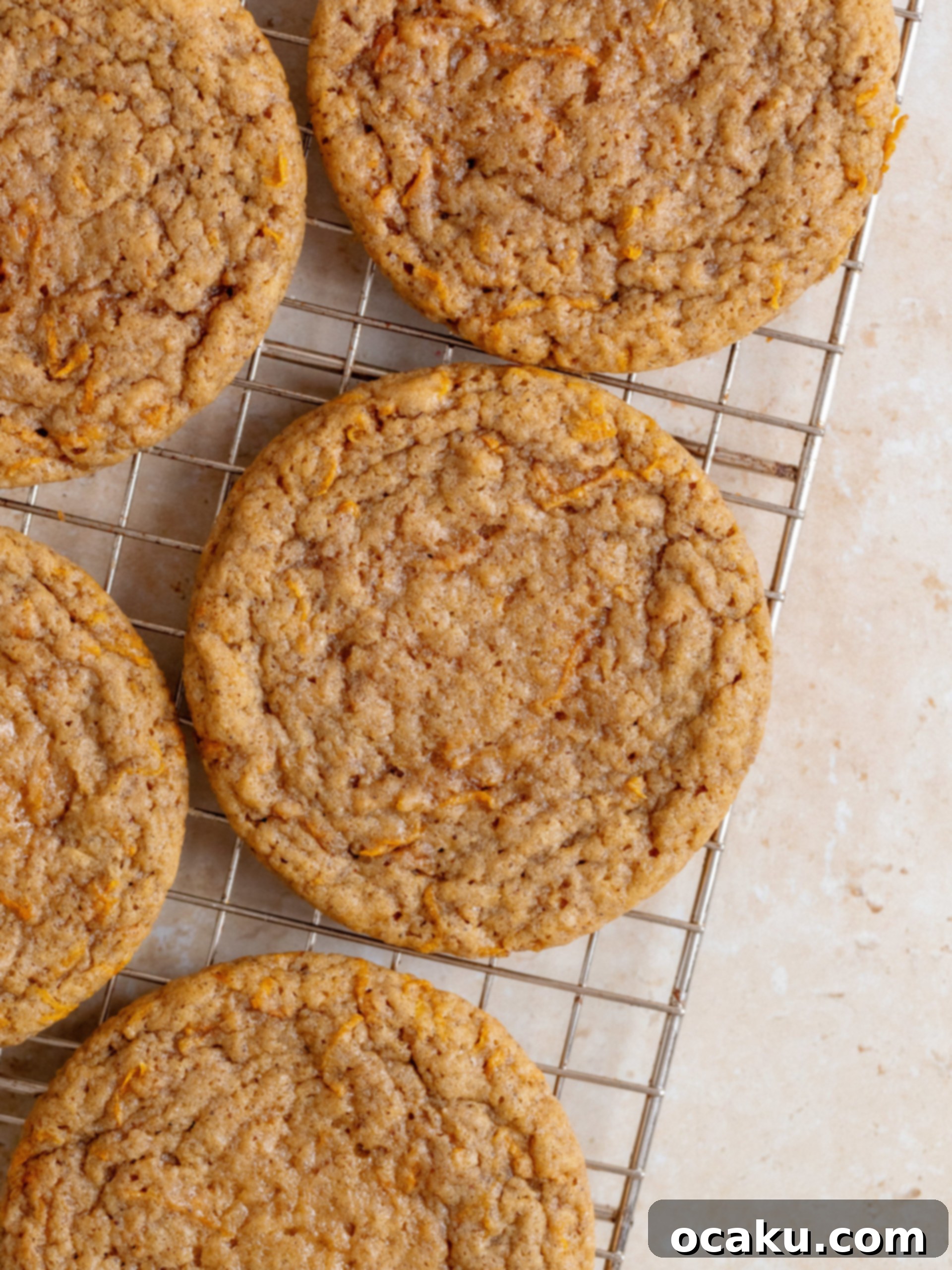 Close-up of baked carrot cake cookies cooling on a wire rack.