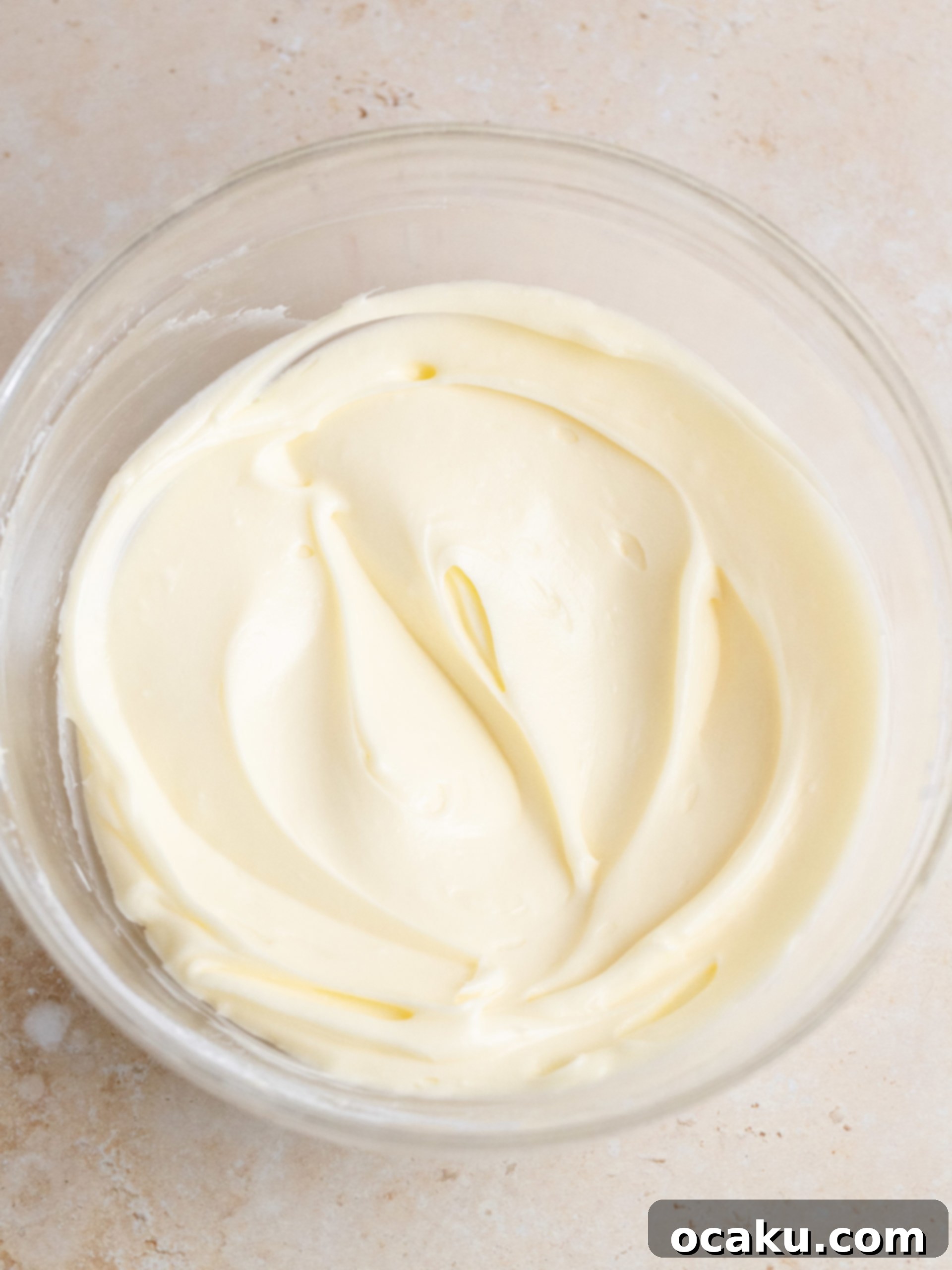 Frosted carrot cake cookies topped with chopped walnuts on a serving plate.