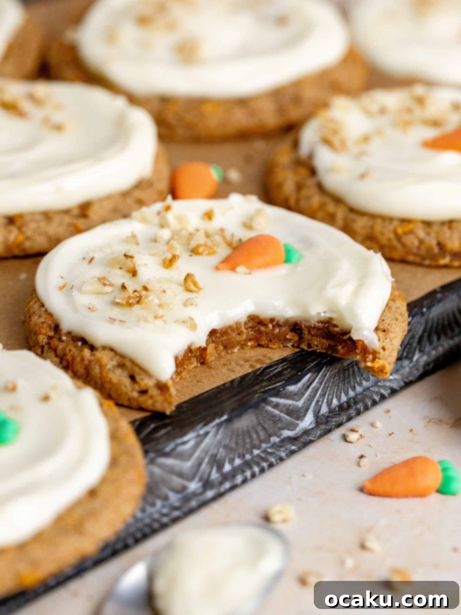 Stack of carrot cake cookies with cream cheese frosting, showing the soft interior.