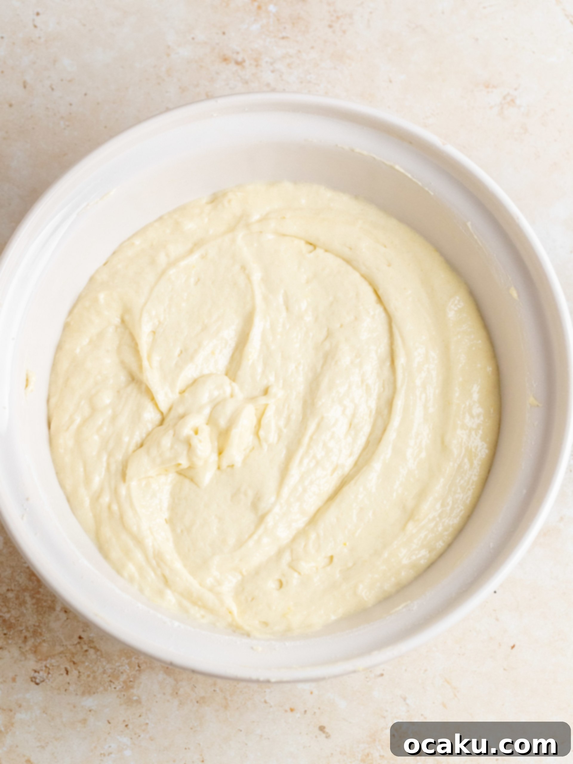 Close-up of lemon zest being rubbed into granulated sugar for maximum flavor.