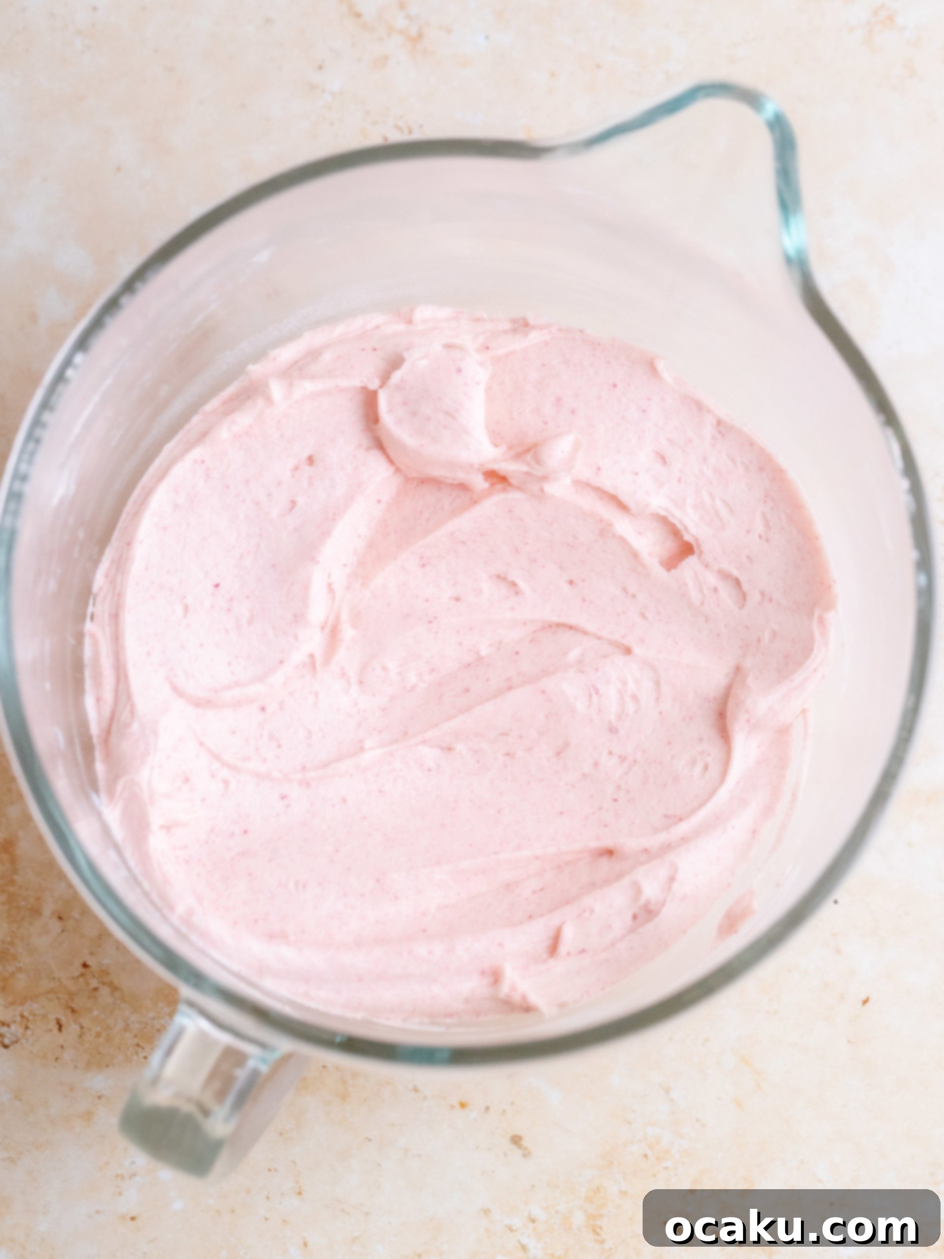 A bowl of creamy, pink raspberry buttercream.
