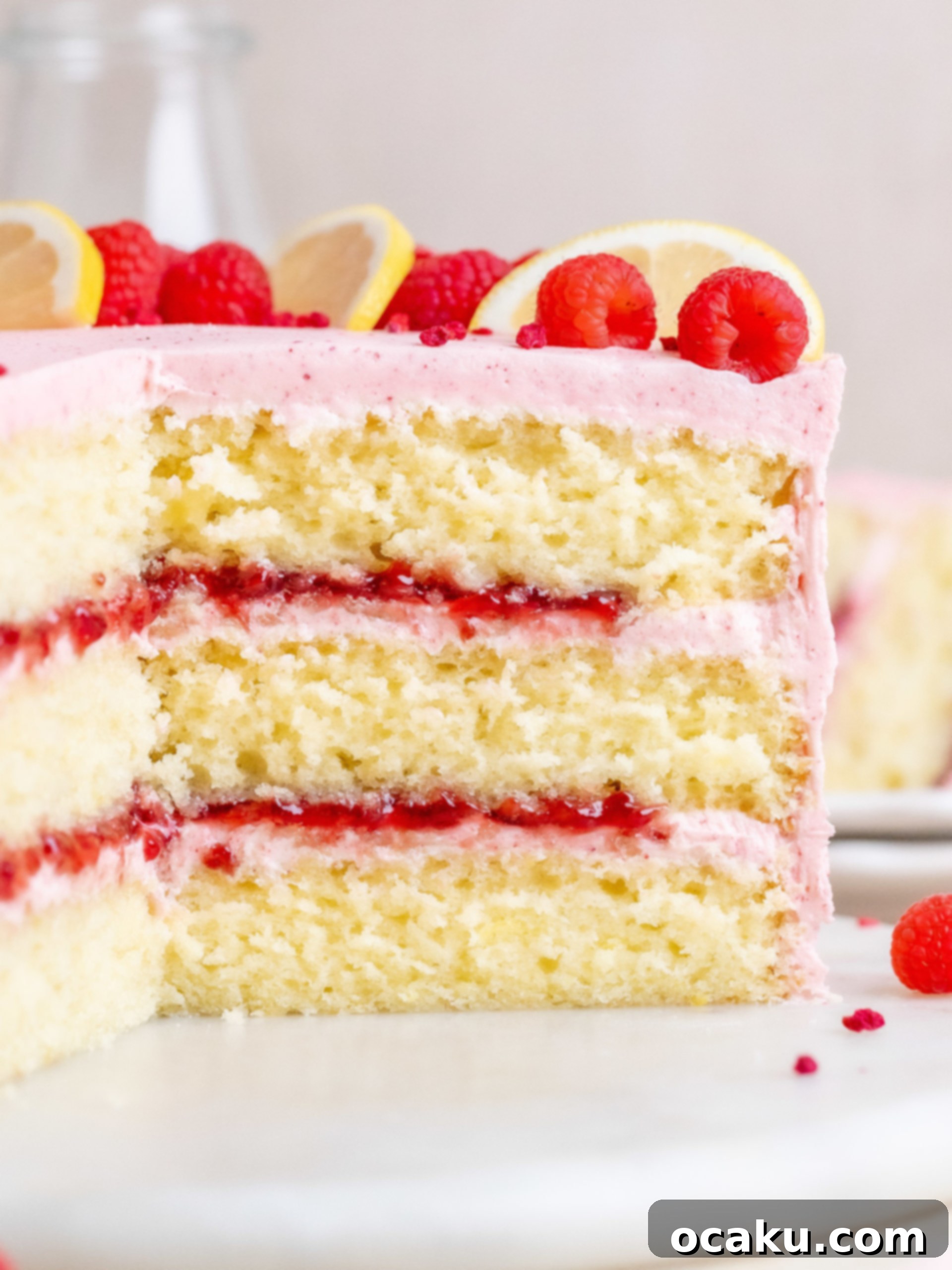 Another close-up of the fully decorated lemon raspberry cake, garnished with fresh raspberries and lemon slices.