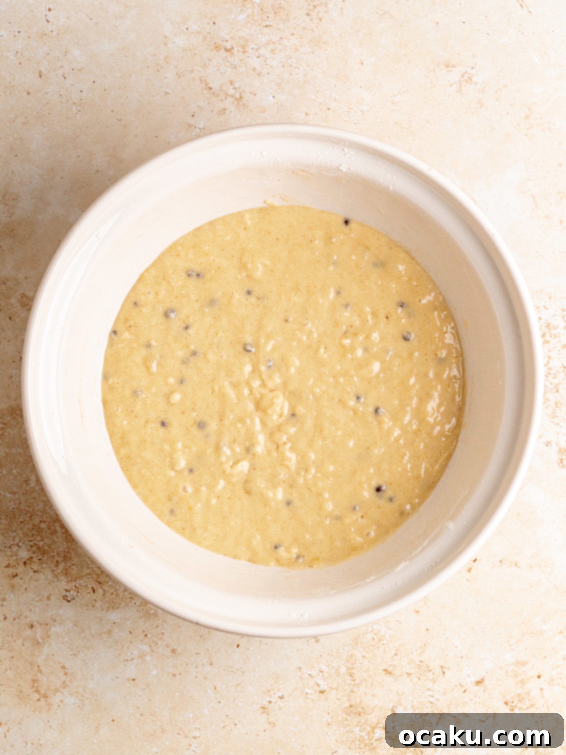 Adding dry ingredients to the wet mixture for the cake batter