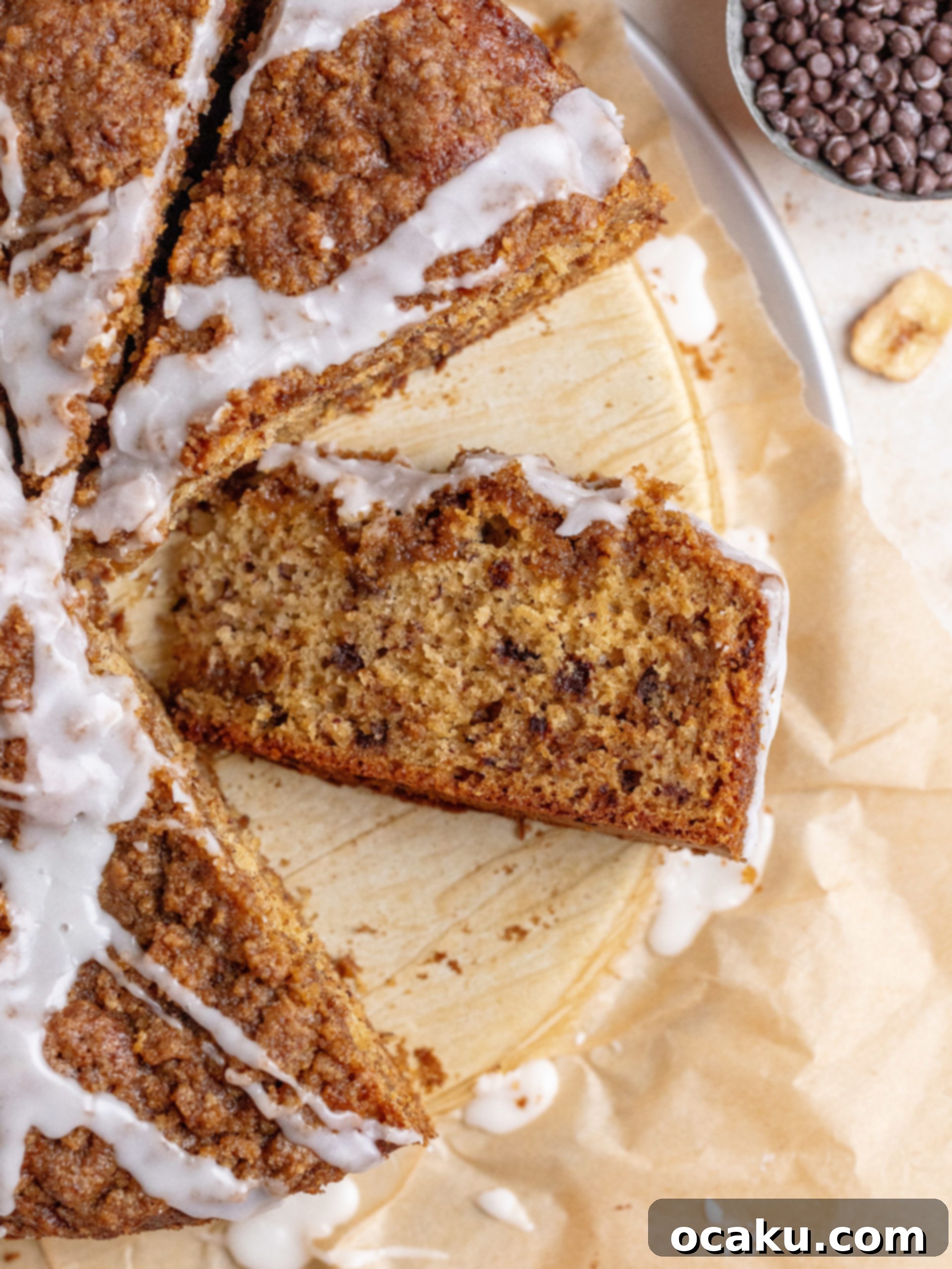 A whole brown butter banana coffee cake with vanilla glaze and streusel on a wire rack