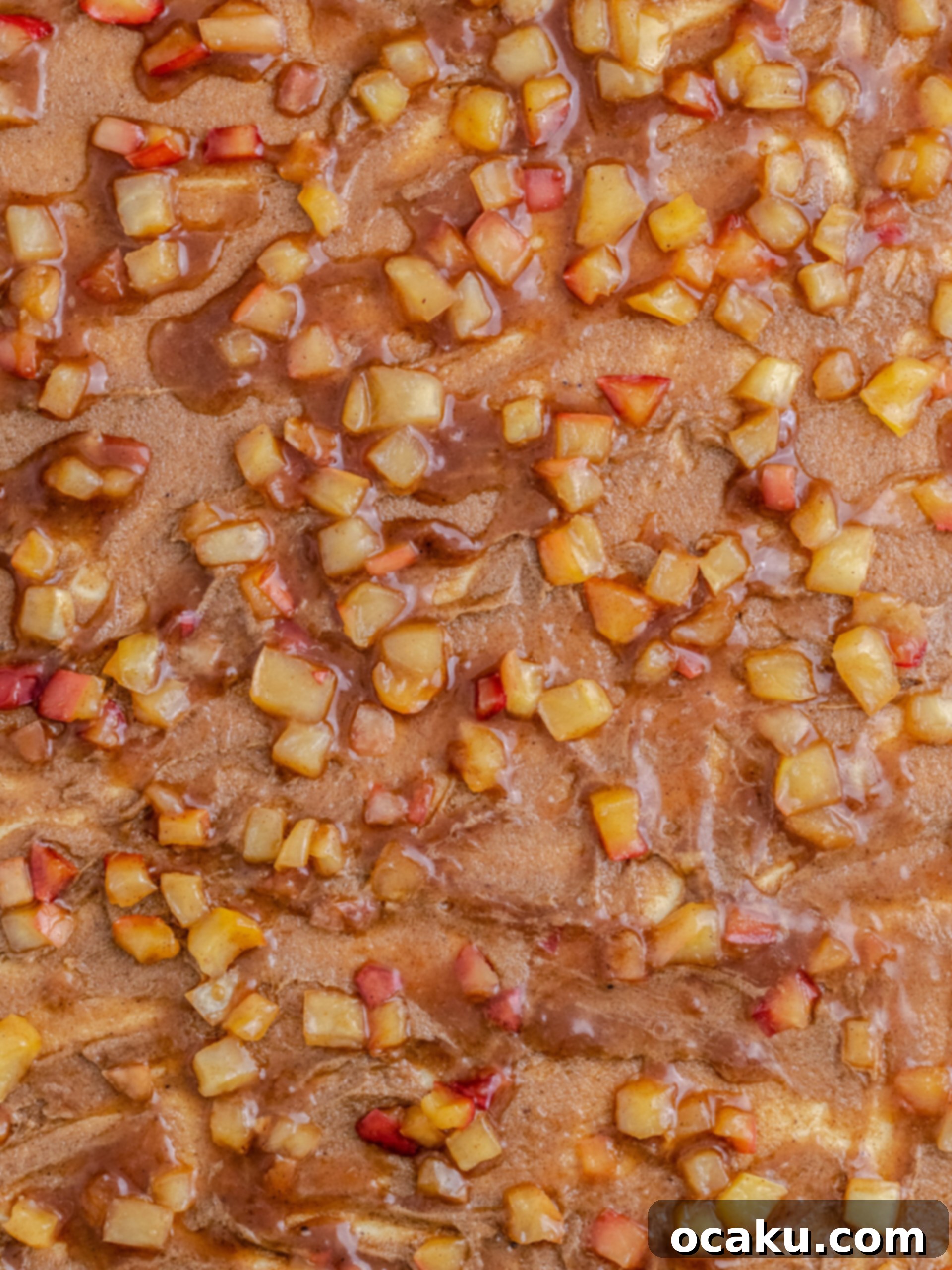 Dough rolled out and covered with both cinnamon sugar and apple pie filling.