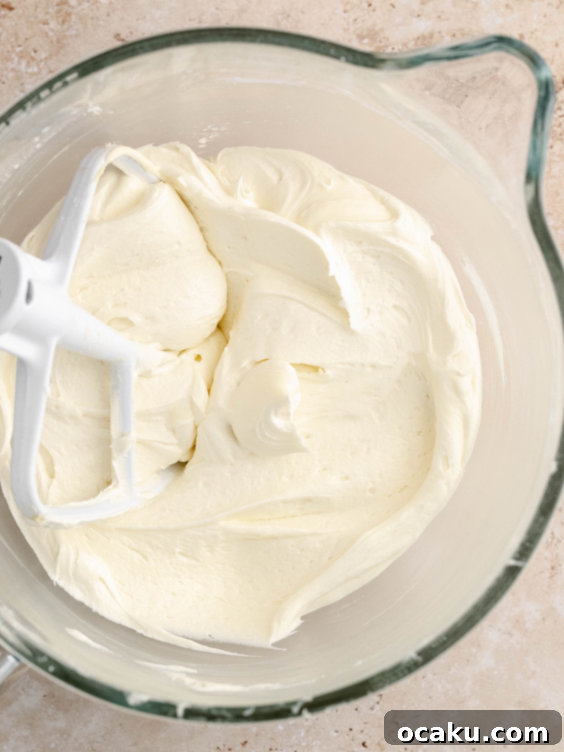 Zesty Lemon Pistachio Cake 4 Smooth and creamy lemon white chocolate buttercream in a mixing bowl, ready for frosting.