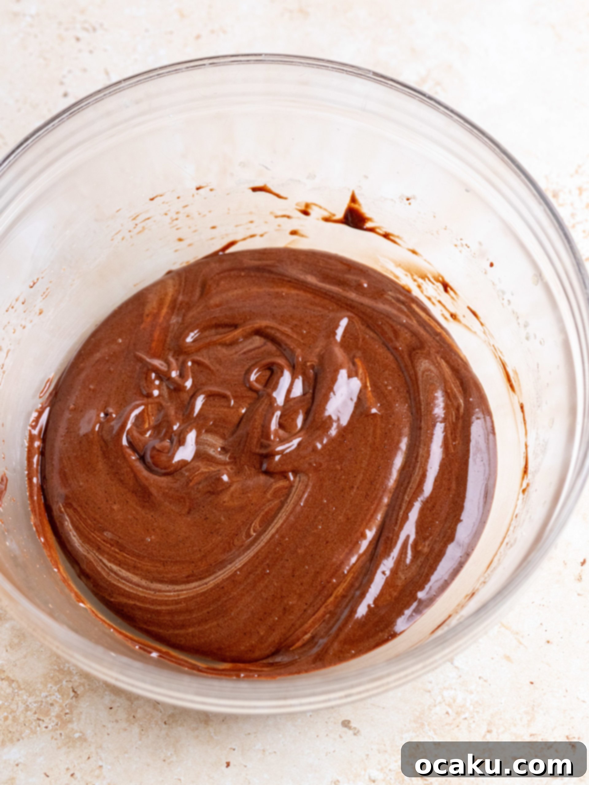 Combining melted chocolate with heavy cream.