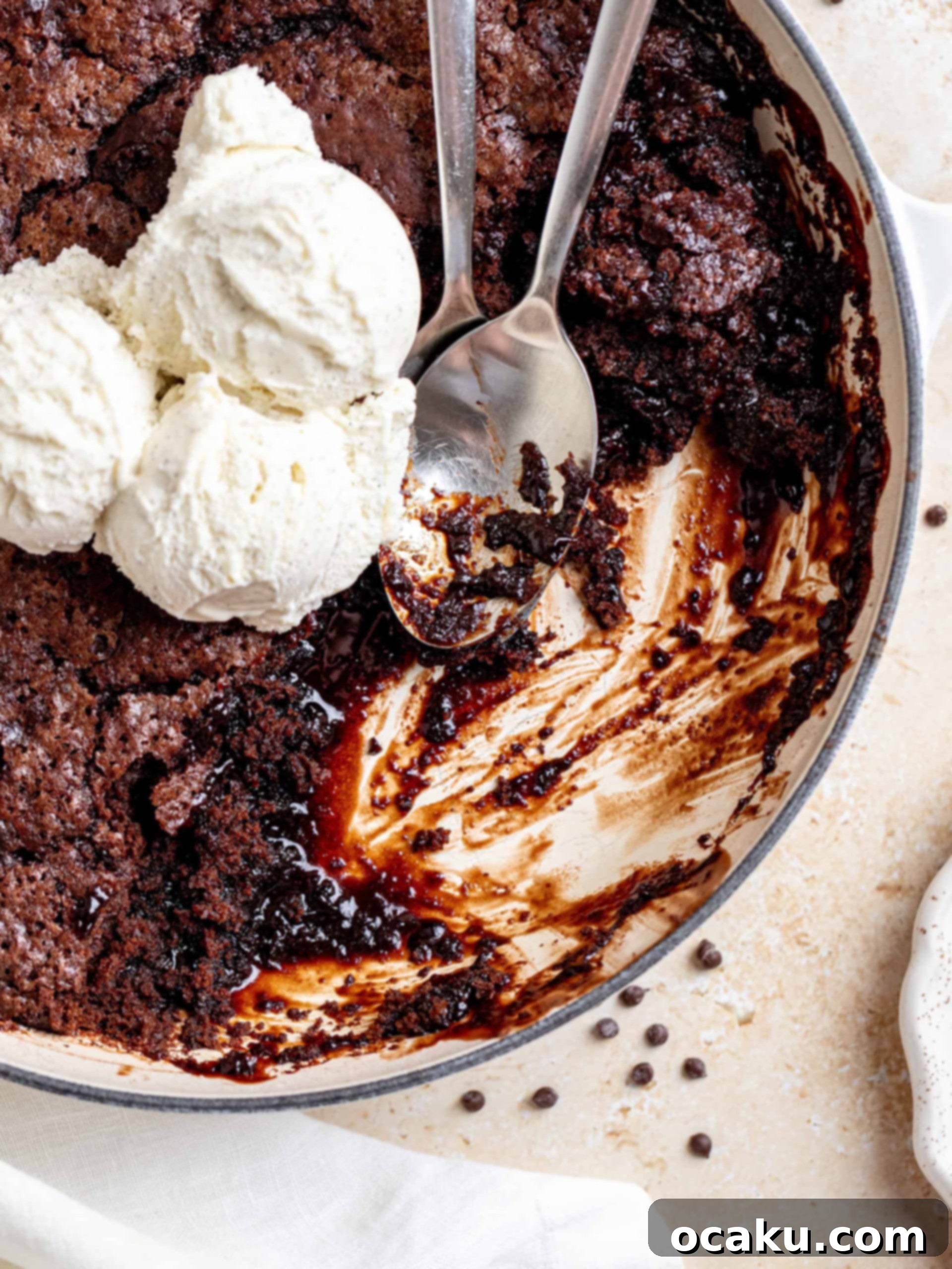 A close-up shot of the perfectly baked Brown Butter Hot Fudge Cake in a rustic cast-iron skillet, viewed from above, ready to be portioned.