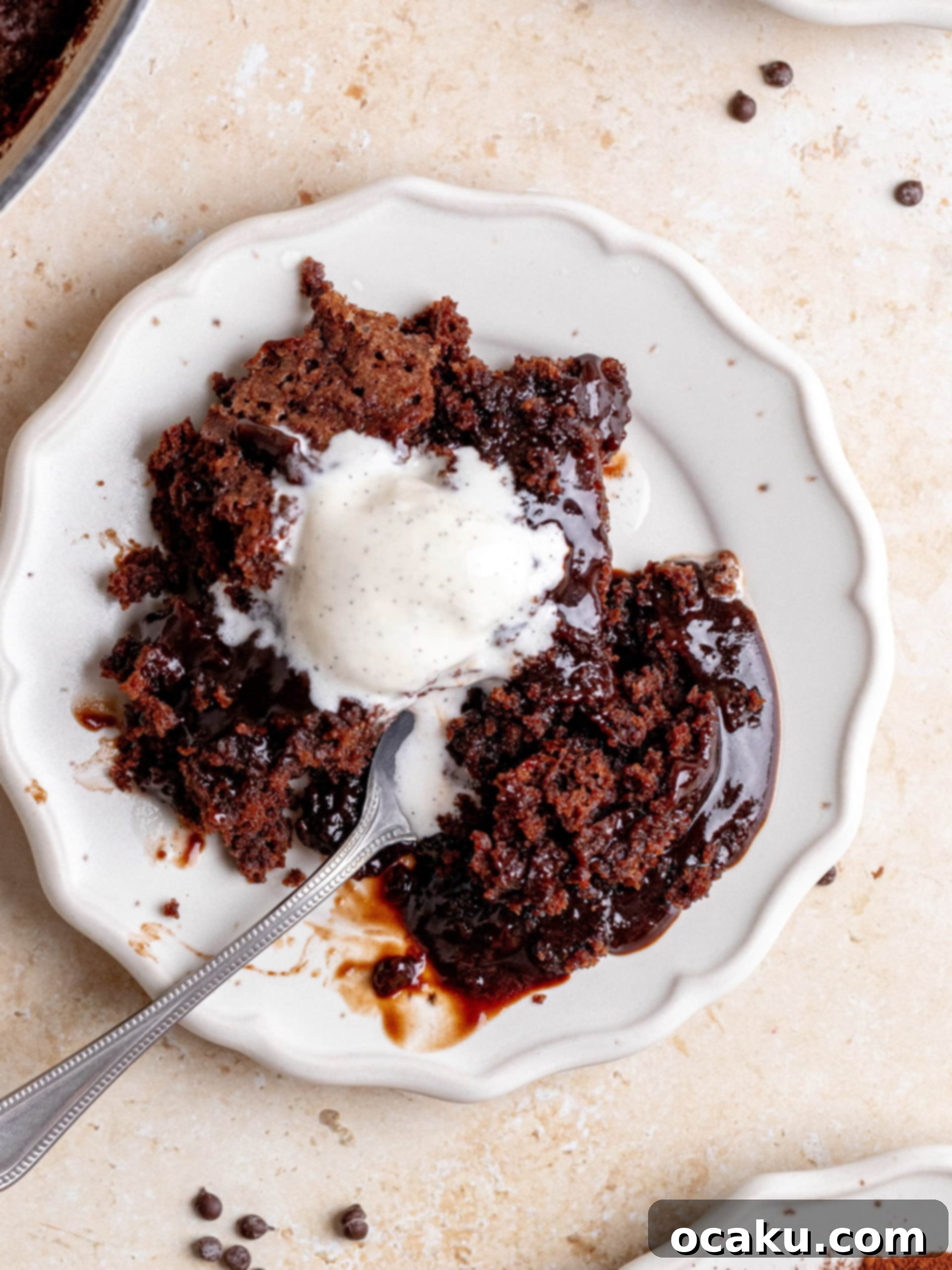 A single, delectable slice of Brown Butter Hot Fudge Cake, still nestled in the cast-iron skillet, with a clear view of the gooey fudge layer, ready for a spoon.