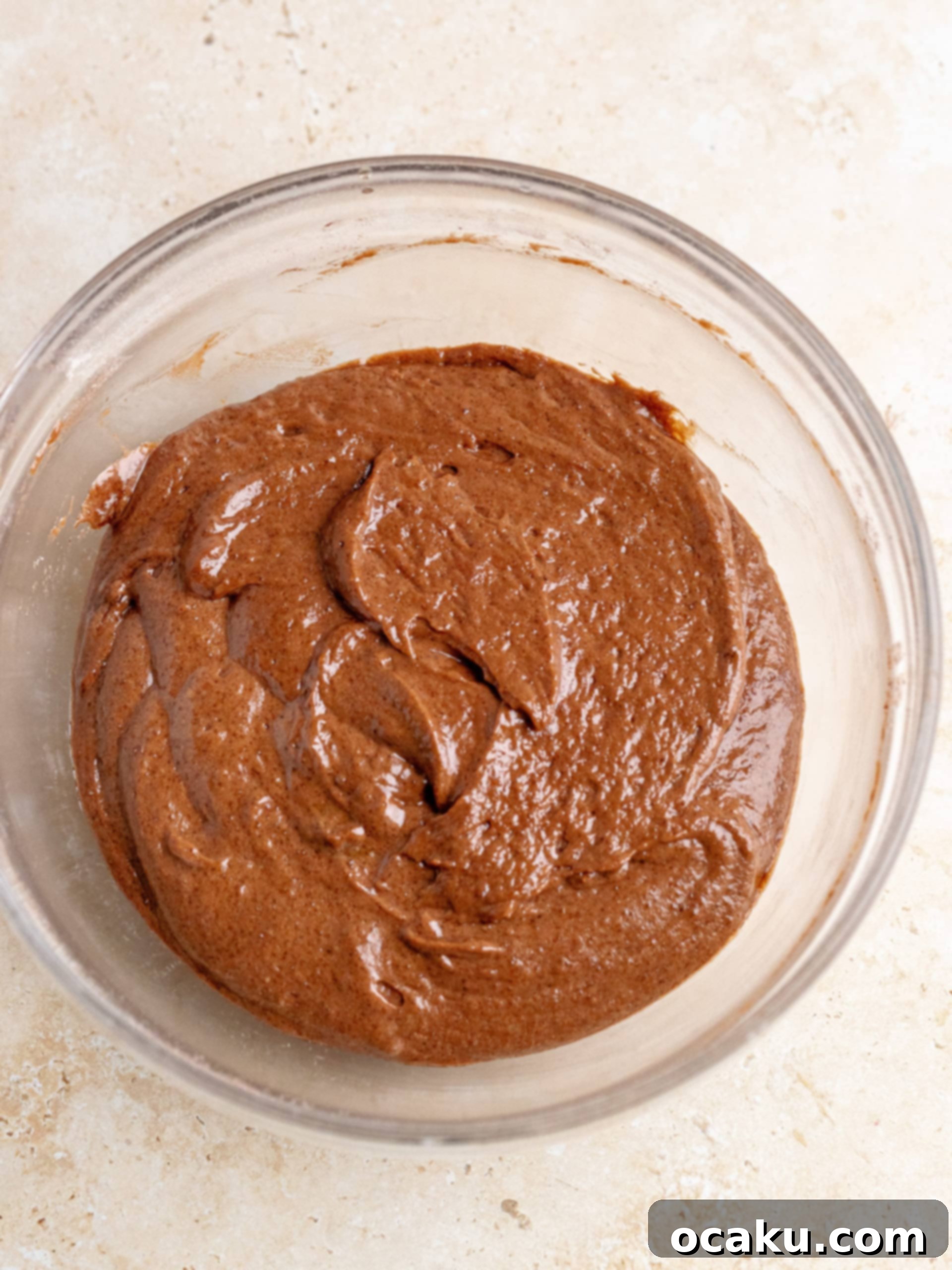 Smooth chocolate cake batter spread evenly in a skillet, topped with the dry granulated sugar, brown sugar, and cocoa powder mixture.