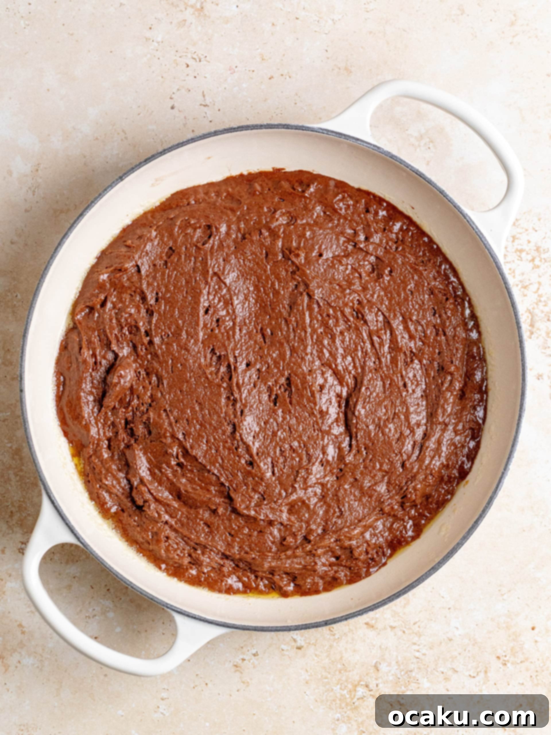 The freshly baked Brown Butter Hot Fudge Cake in a cast-iron skillet, with a slightly crisp top, just removed from the oven.