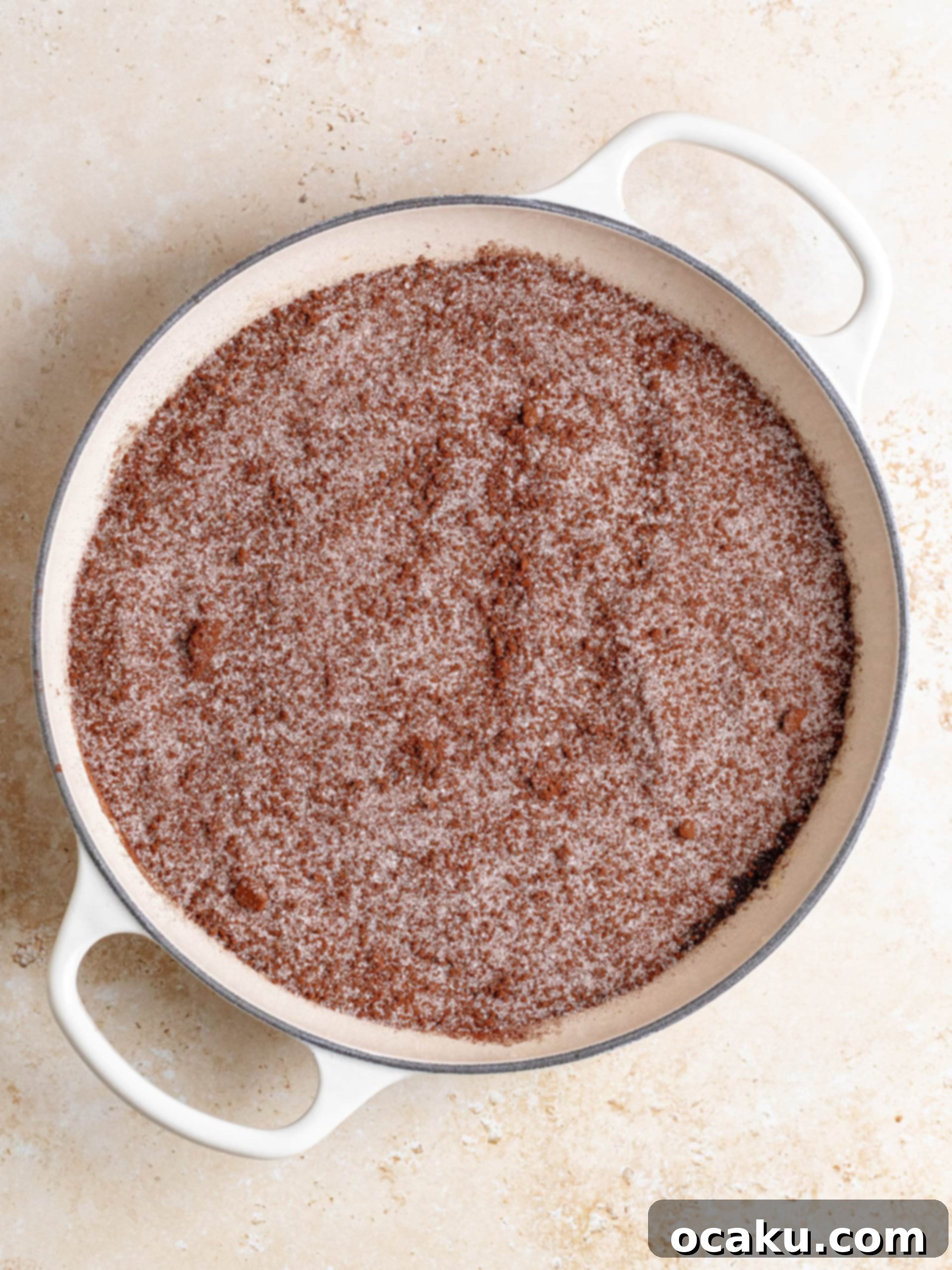 A close-up of the molten, dark hot fudge sauce bubbling gently beneath the soft chocolate cake layer.