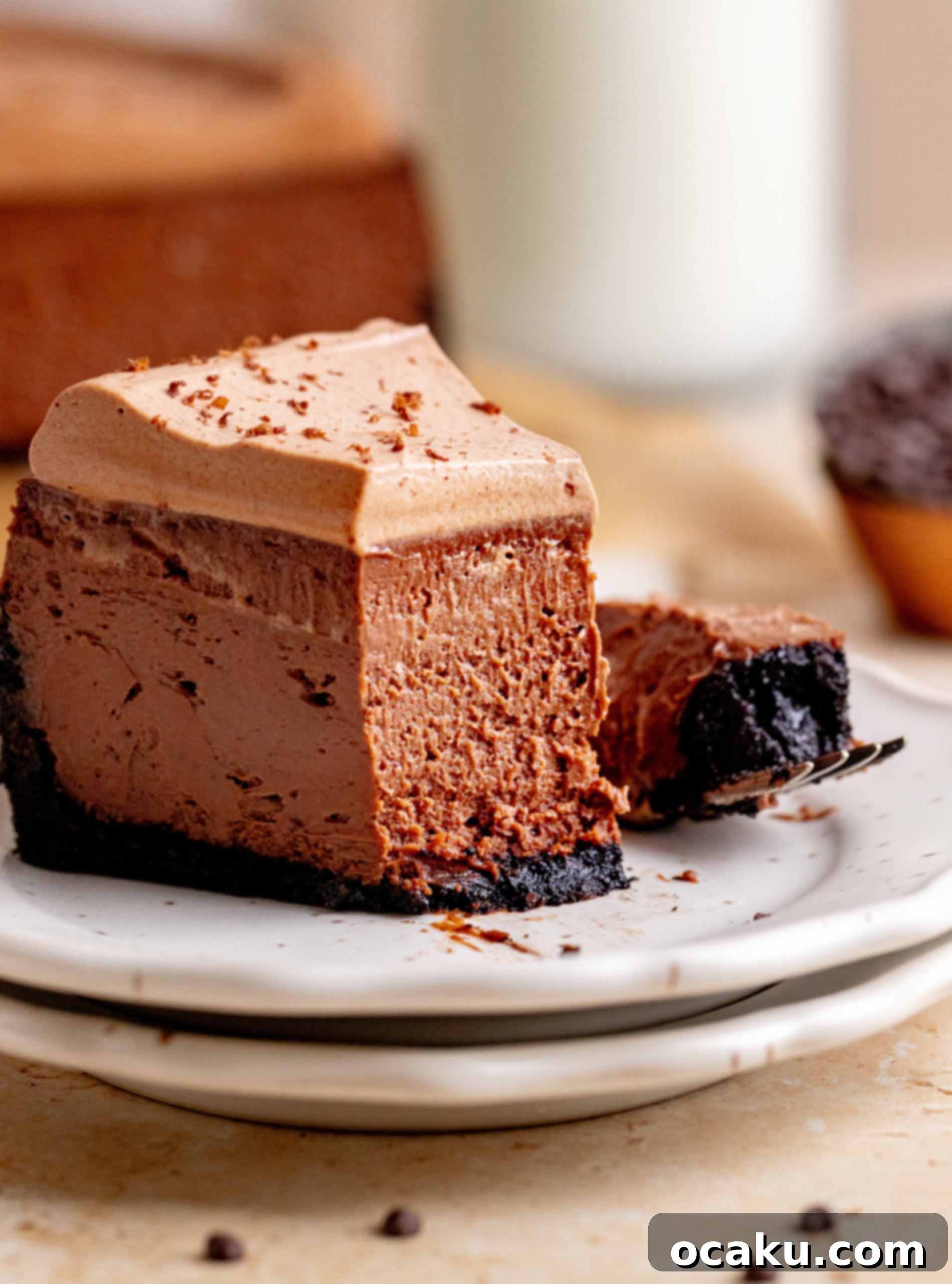 Decadent Chocolate Cheesecake 2 A rich chocolate cheesecake with a thick whipped dark chocolate ganache on top, sitting on a wooden surface. Perfect for chocolate lovers.