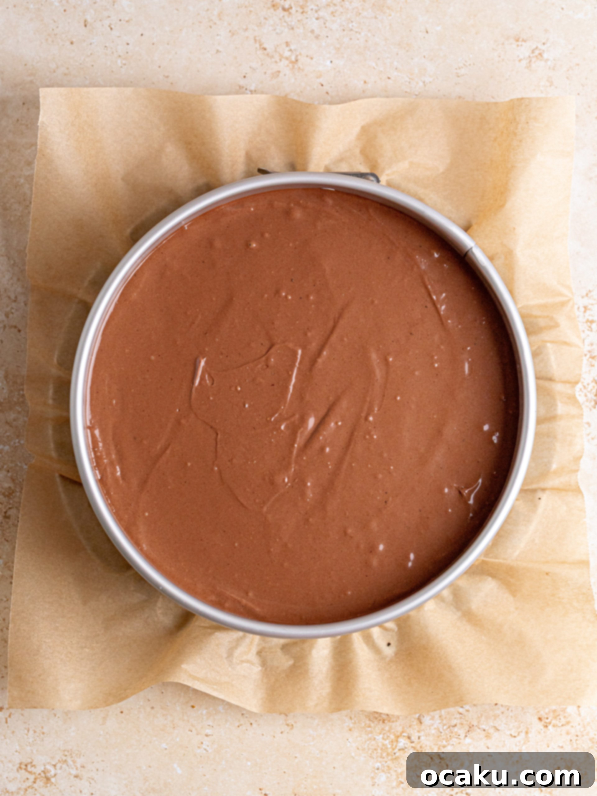 Decadent Chocolate Cheesecake 8 A springform pan containing cheesecake batter carefully placed in a larger pan for a water bath, ensuring no leaks.