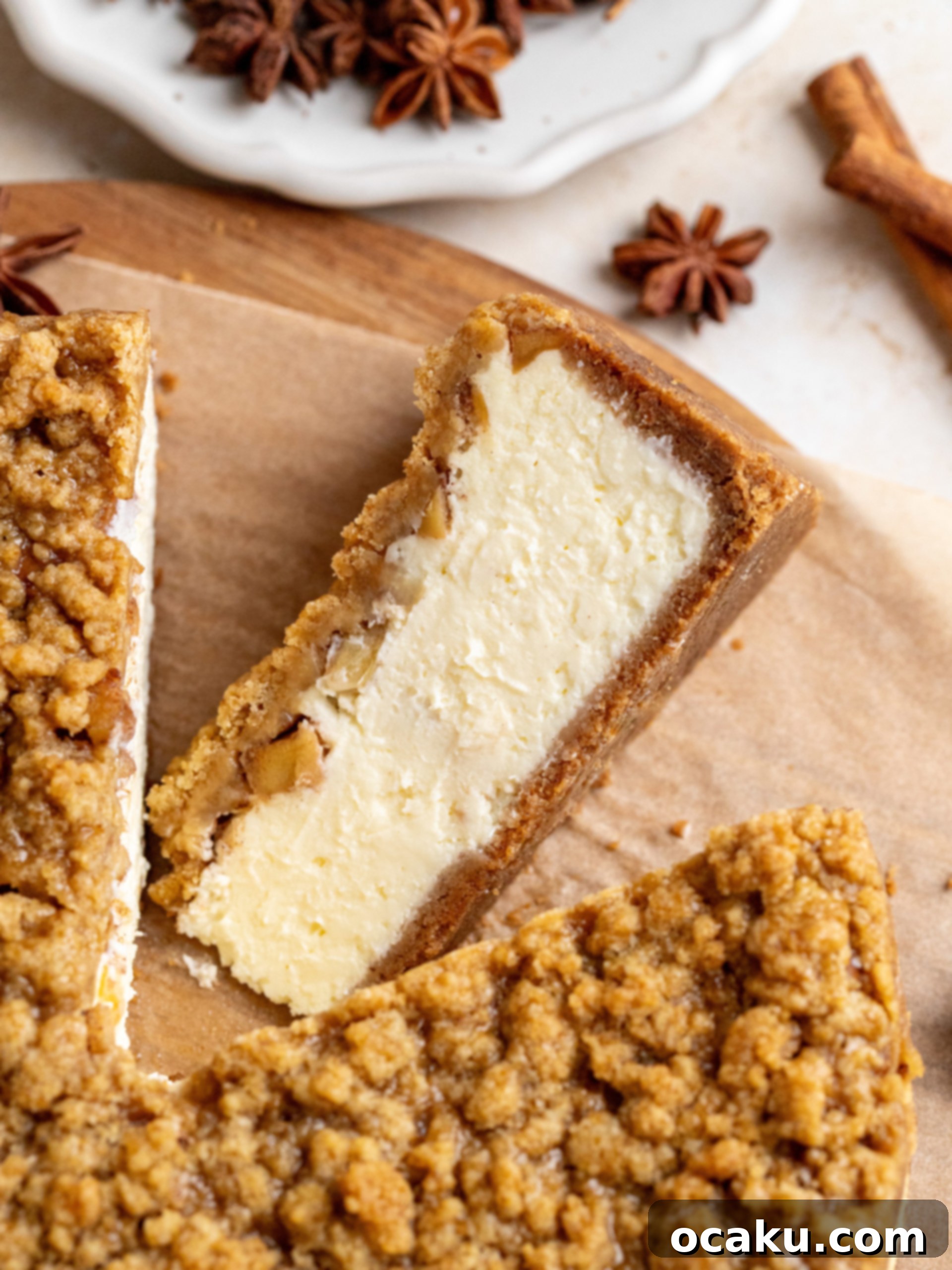 A perfect slice of Apple Crumble Cheesecake on a plate, garnished with a sprig of mint, ready to be served.