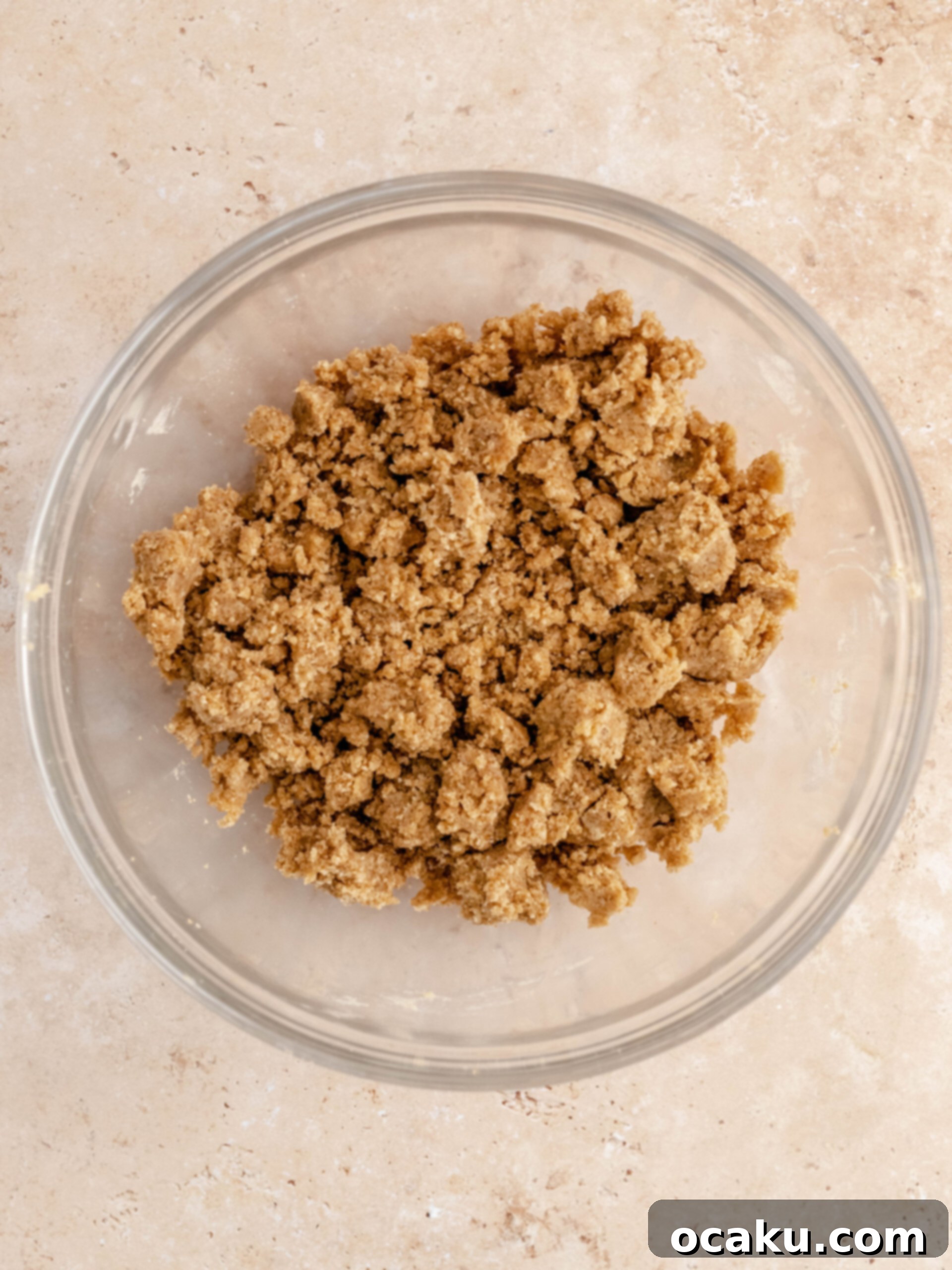 Bowl of buttery, golden streusel crumble, prepared to top the apple crumble cheesecake.
