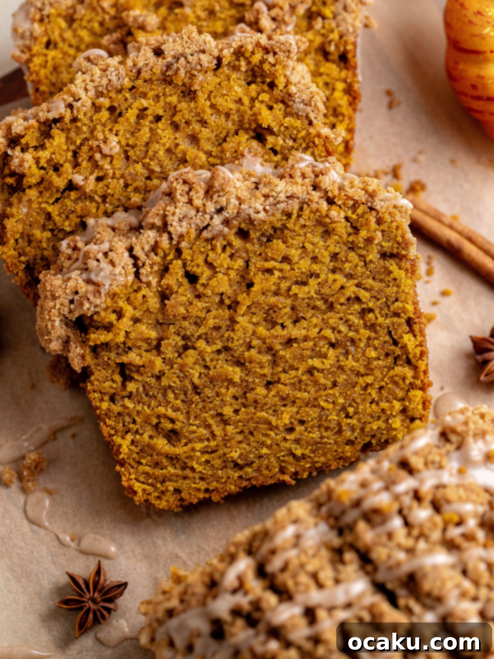 Pumpkin Perfection Loaf with Crumbly Topping and Spice Drizzle 7 A perfectly sliced piece of pumpkin bread with streusel and glaze, showcasing its moist interior.