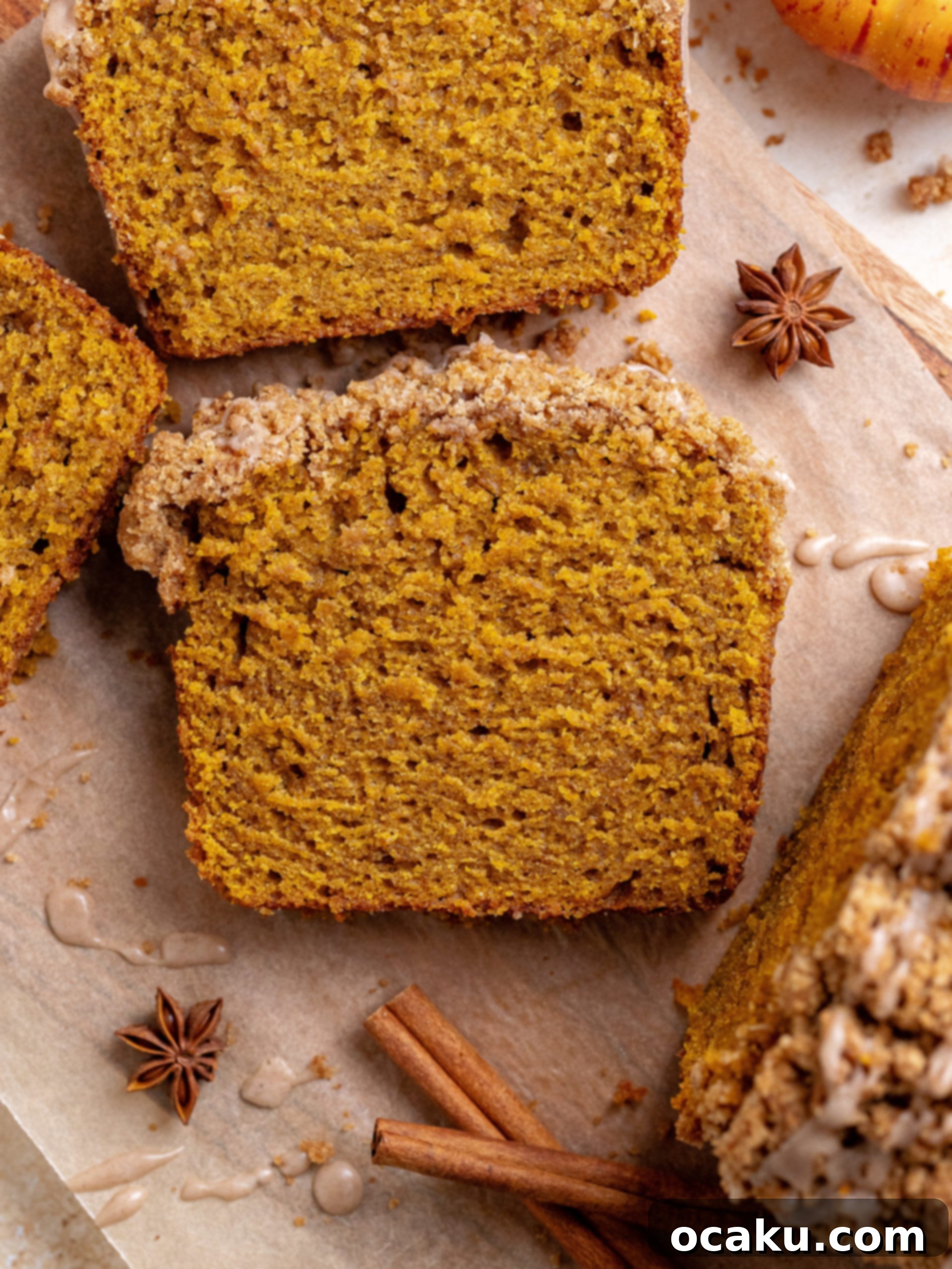 Pumpkin Perfection Loaf with Crumbly Topping and Spice Drizzle 8 Close-up of a stack of pumpkin bread slices with streusel and glaze, ready to be enjoyed.