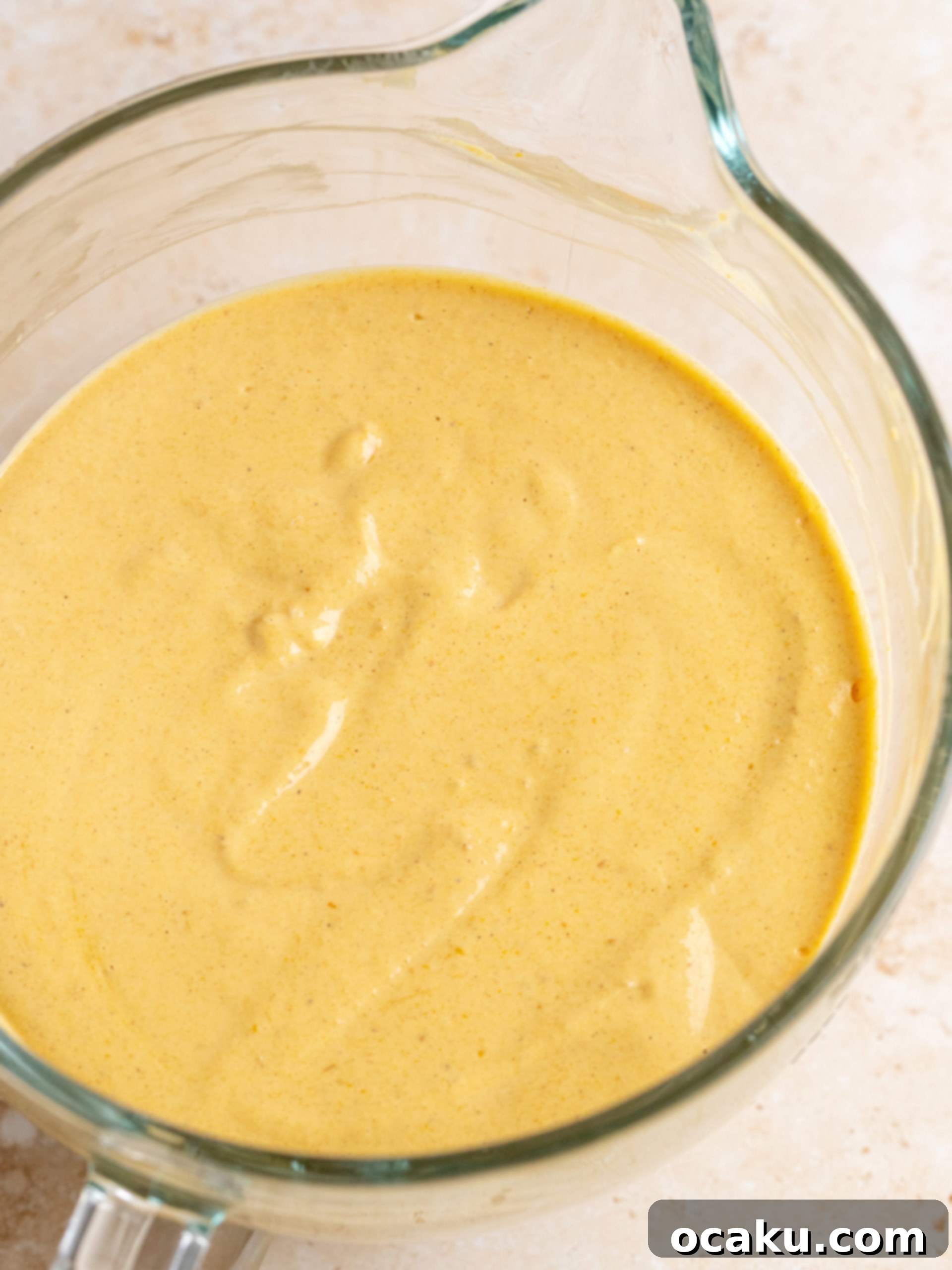 A large mixing bowl filled with the smooth, creamy pumpkin cheesecake batter, ready for pouring.