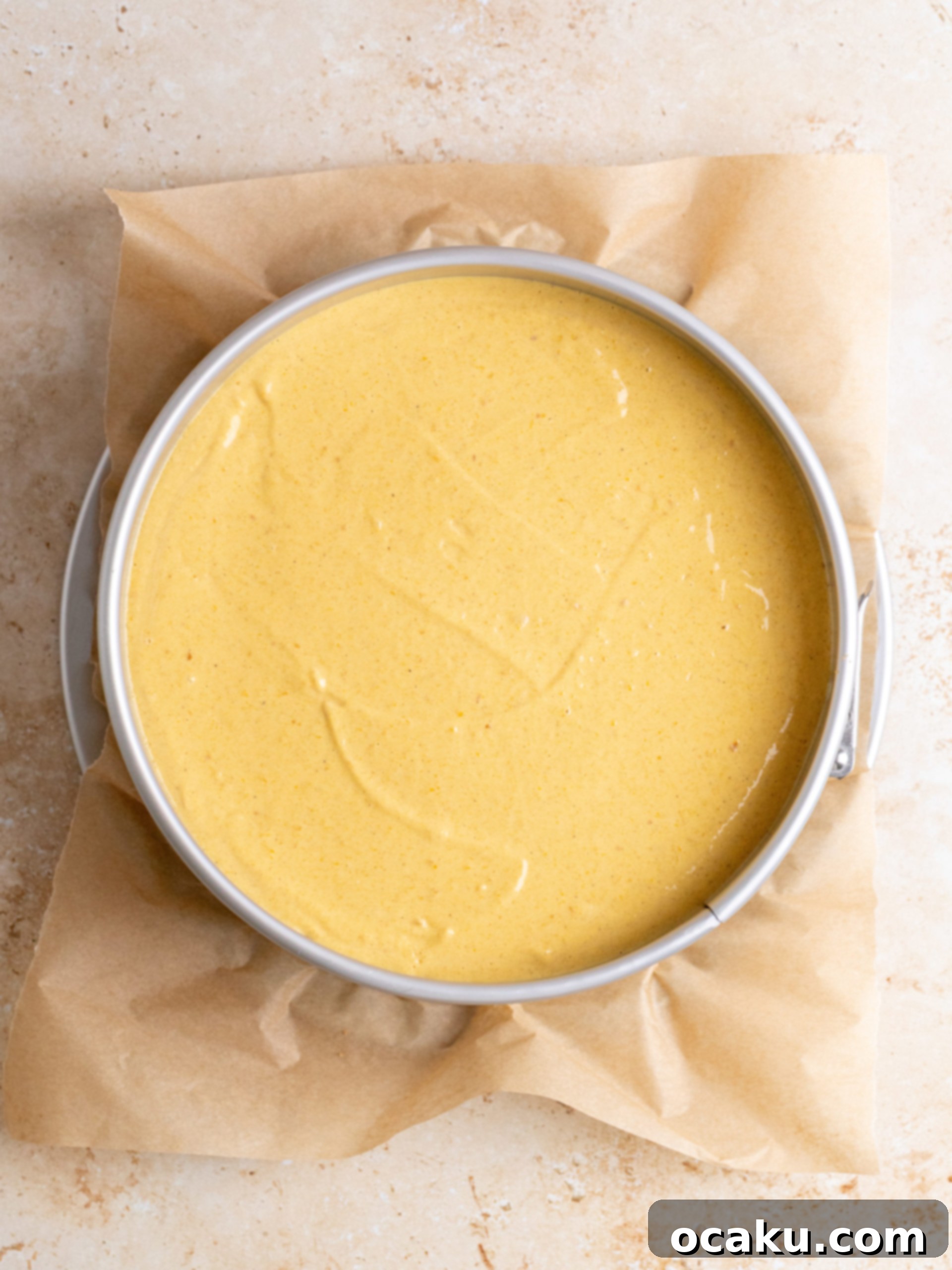 The fully baked pumpkin cheesecake still in its springform pan, showing its golden-brown edges.