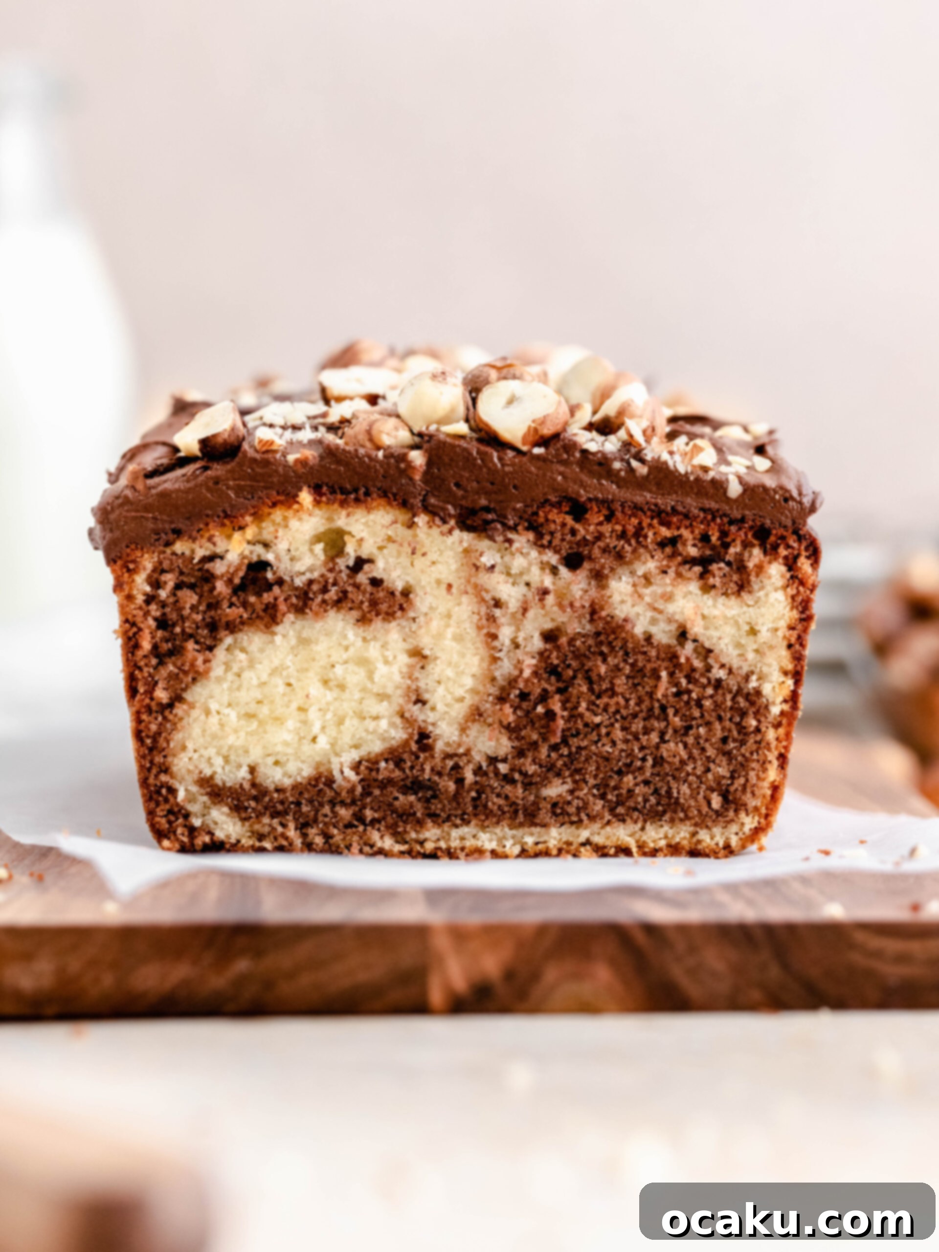 A stunning Nutella loaf cake with a visible marbled swirl, presented on a rustic wooden tray, ready to be sliced and enjoyed.
