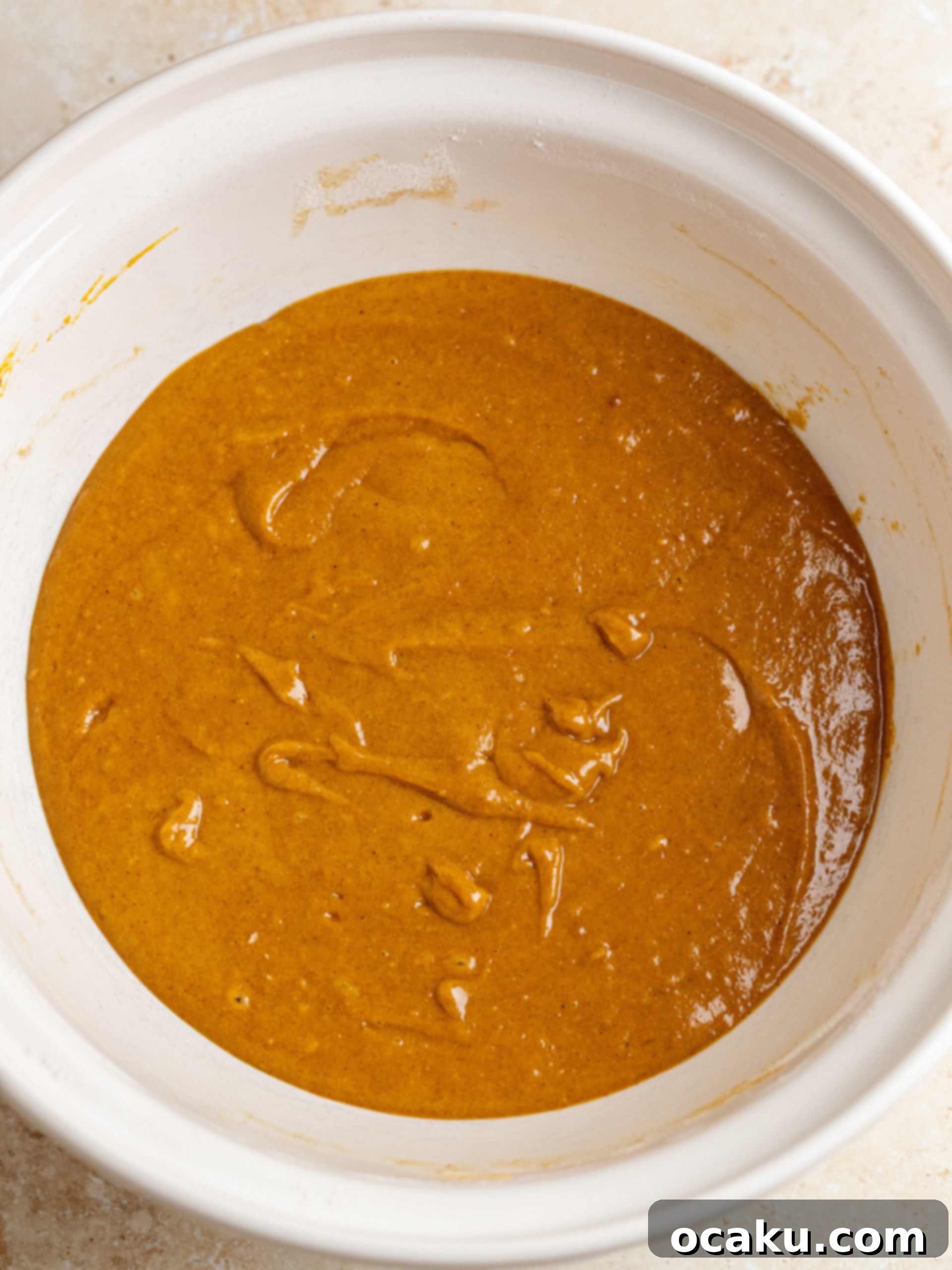 Maple Caramel Pumpkin Cake with Whipped Cream Cheese 4 Two bowls, one with dry cake ingredients (flour, spices) and another with wet ingredients (brown butter, sugar, pumpkin puree).