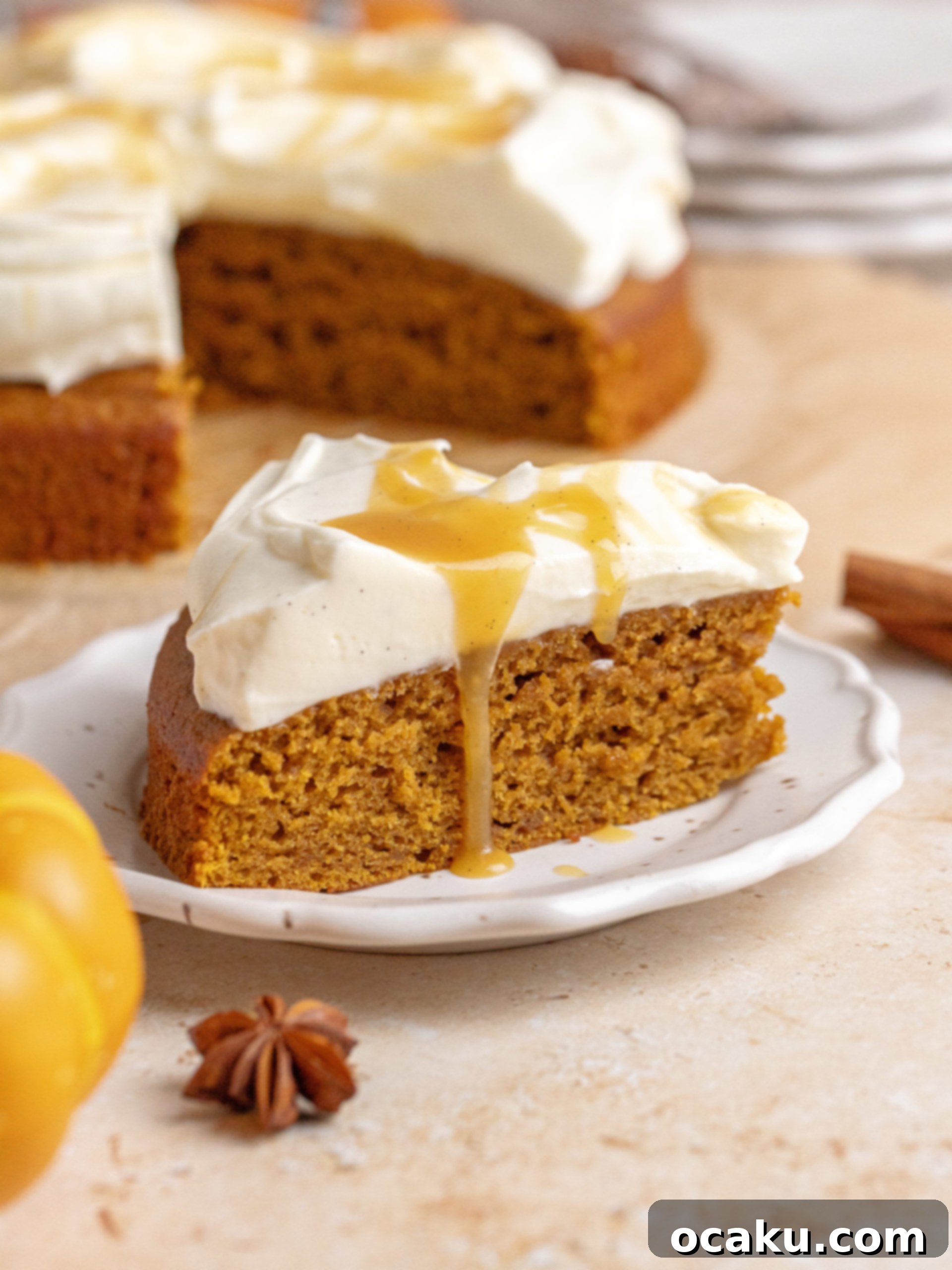Maple Caramel Pumpkin Cake with Whipped Cream Cheese 9 An assembled brown butter pumpkin cake on a rustic wooden board, ready to be served, surrounded by autumn decor.