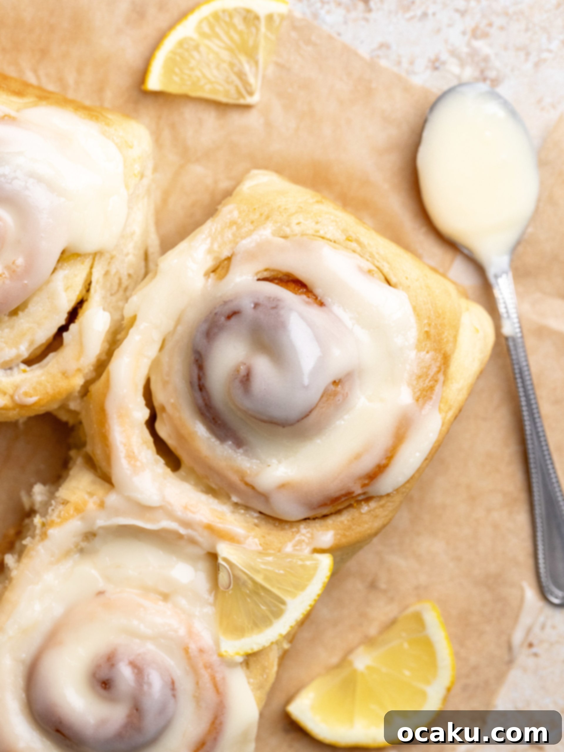 A single lemon roll with frosting, ready to be eaten.