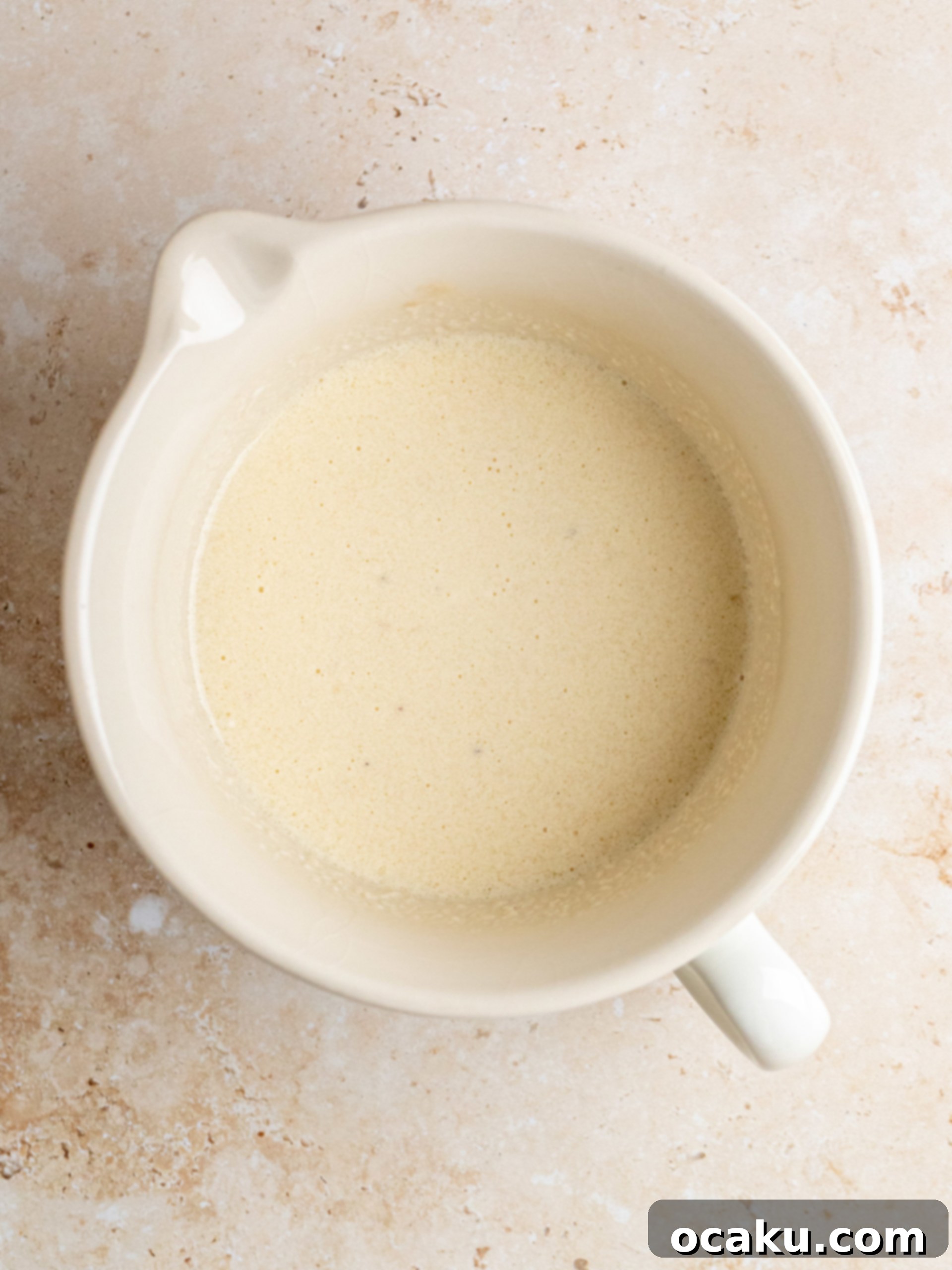 Step-by-step image of mixing wet ingredients for cupcakes.