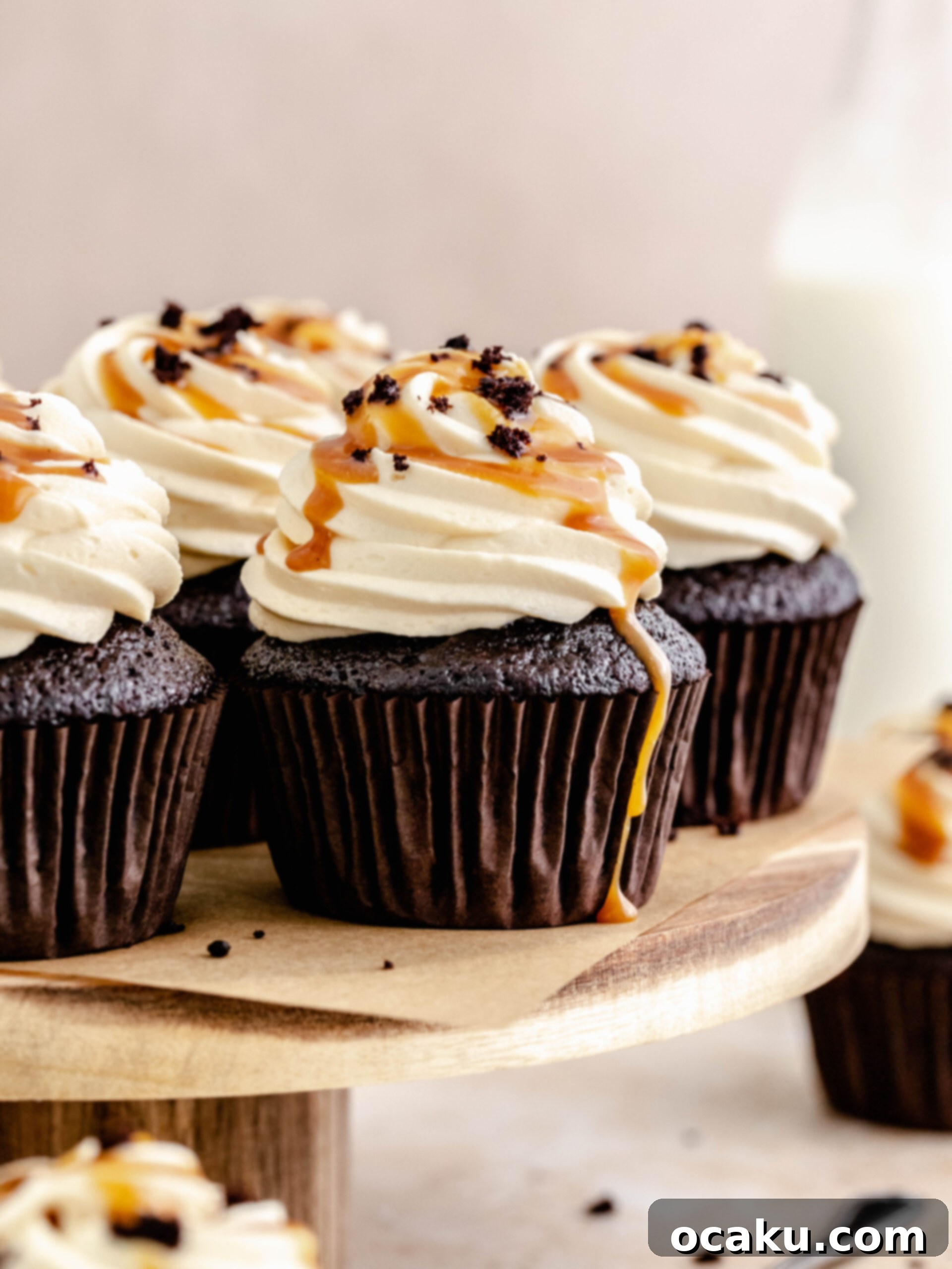 Beautifully decorated caramel filled cupcakes on an elegant cake stand, drizzled with caramel and cake crumbs.
