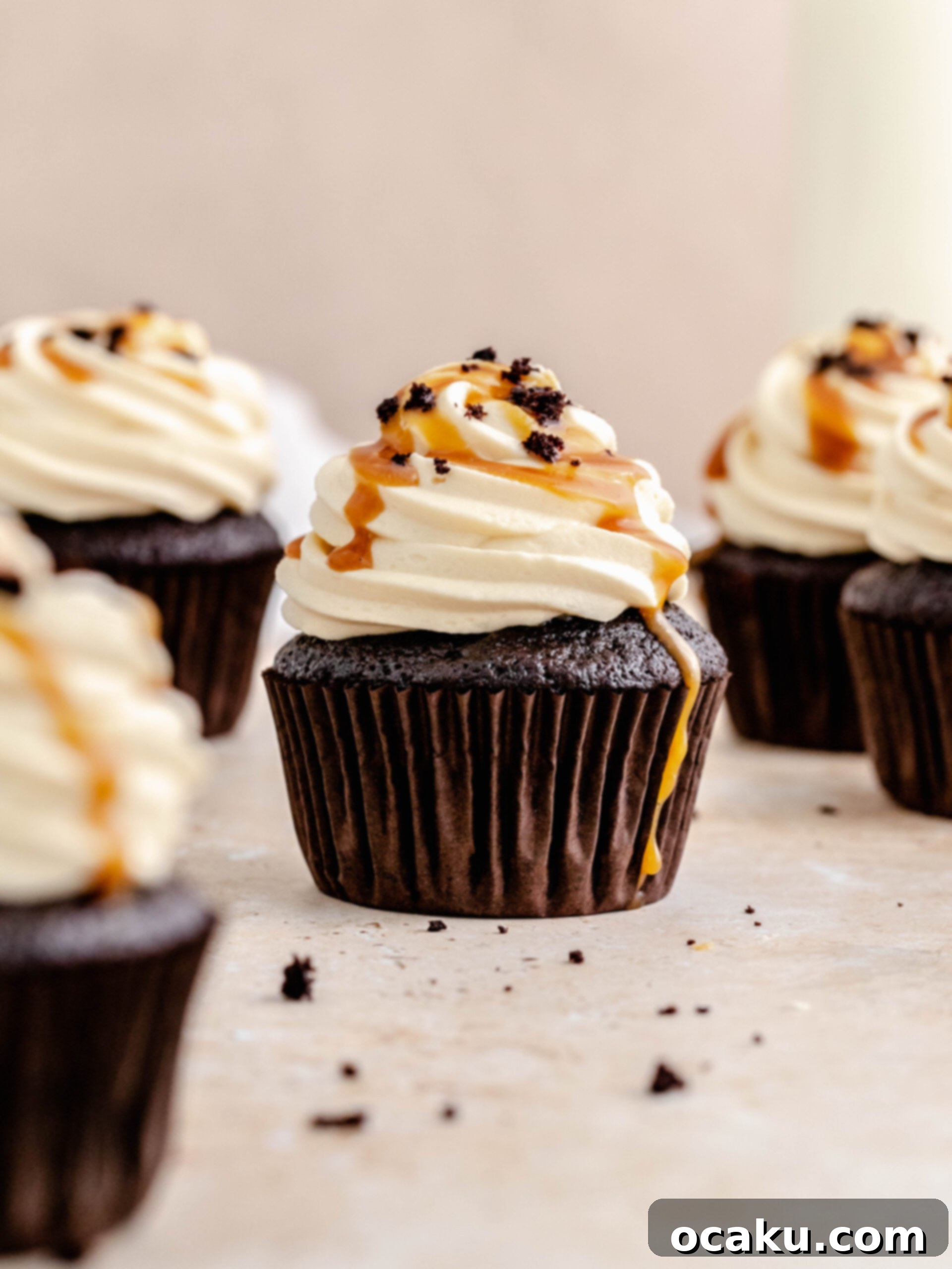 Close-up of a caramel filled chocolate cupcake being frosted with caramel buttercream.