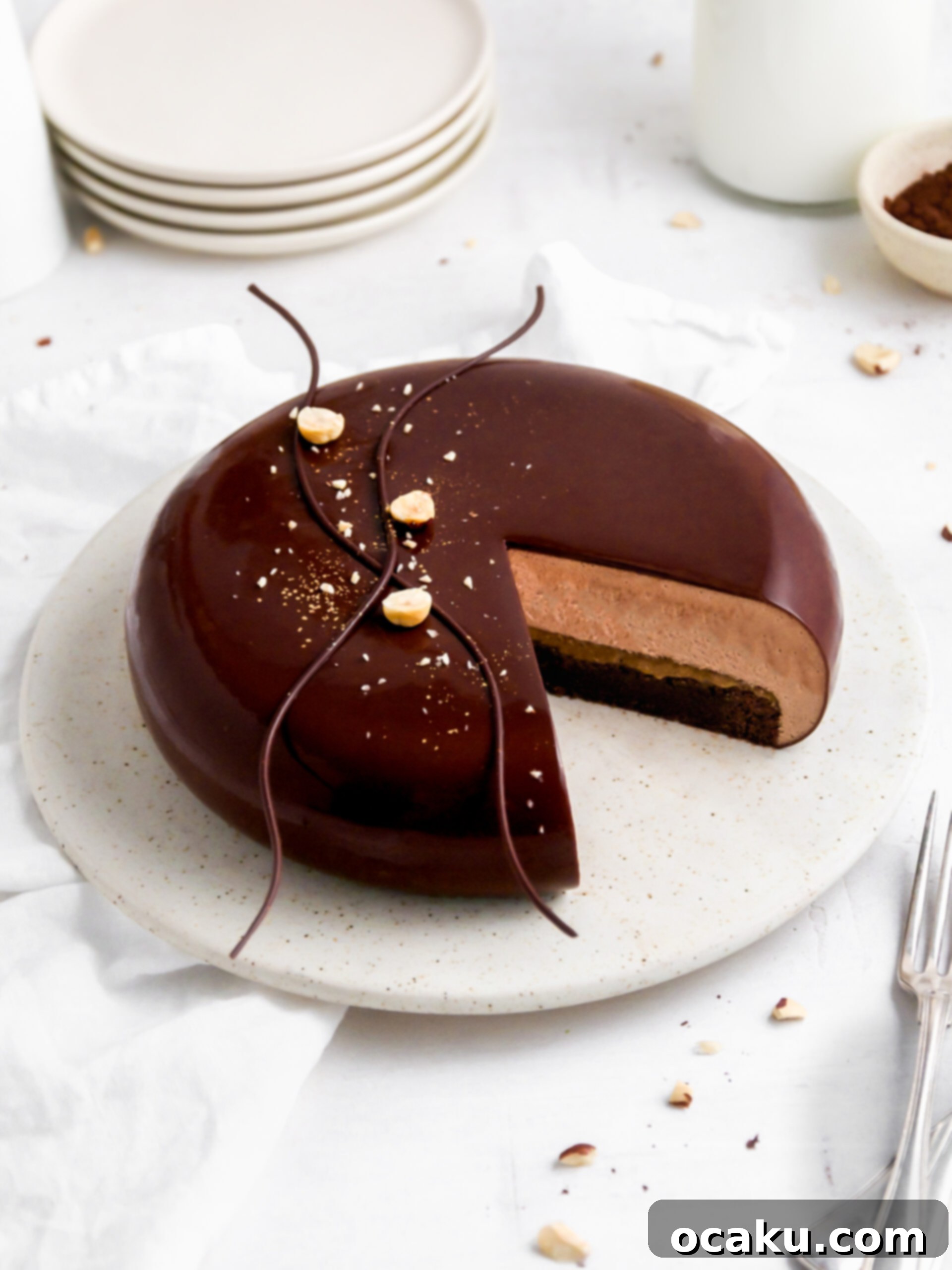 Decadent Nutella Brownie Mousse Cake 4 A slice taken from the impressive Brownie and Nutella mousse cake, showing all layers, beautifully garnished with chocolate waves, hazelnuts, and edible gold dust.