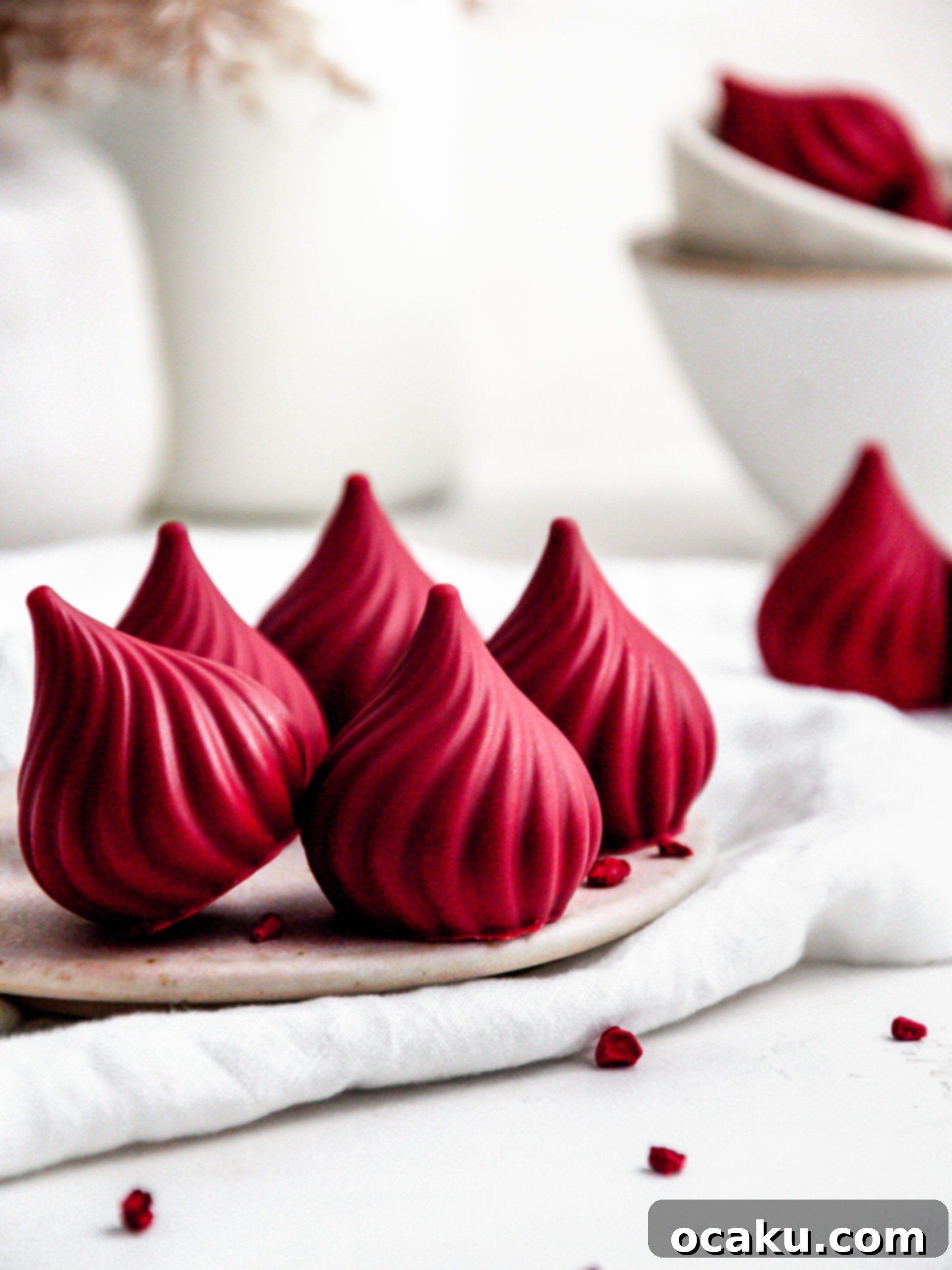 Close-up of raspberry cream puffs on a white plate, showing the smooth chocolate shell and fluffy interior.