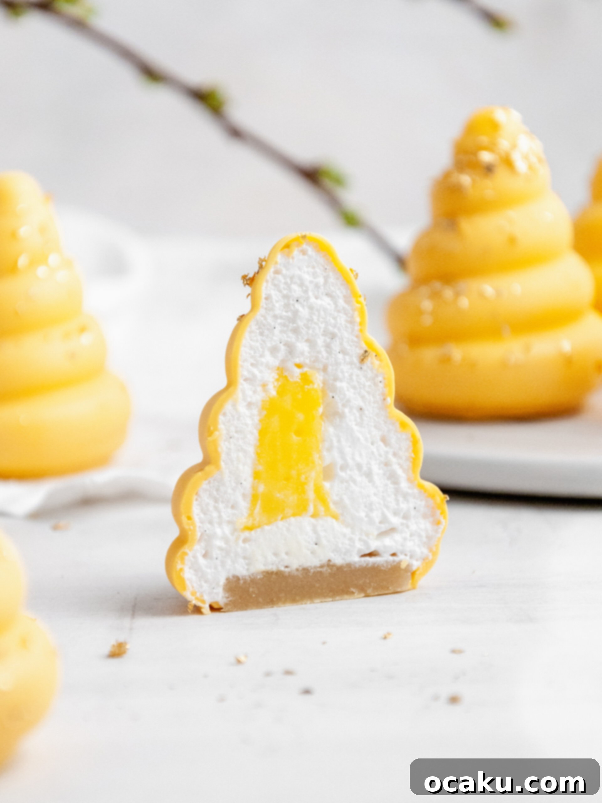 Two lemon cream puffs, one whole and one cut in half, revealing the creamy lemon curd and marshmallow filling.