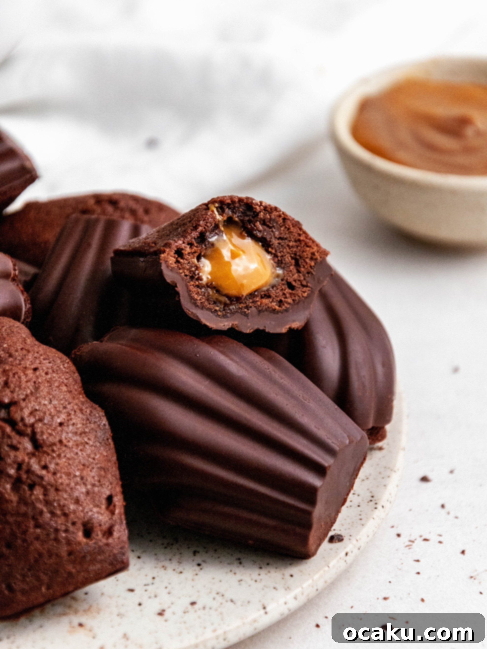 Decadent Chocolate Madeleines with Dulce de Leche 2 Chocolate madeleines with Dulce de Leche cut in half, revealing the luscious caramel filling.