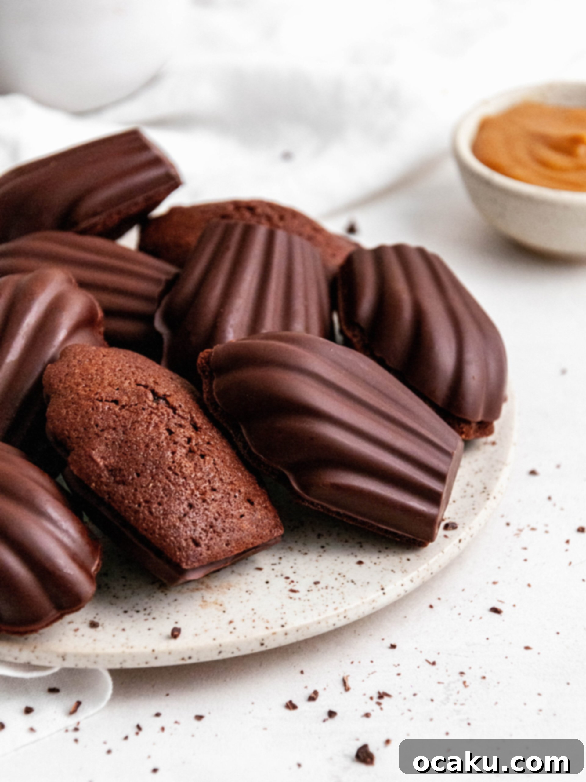 Decadent Chocolate Madeleines with Dulce de Leche 3 Chocolate madeleines with Dulce de Leche on a plate, showcasing their elegant shape and chocolate coating.