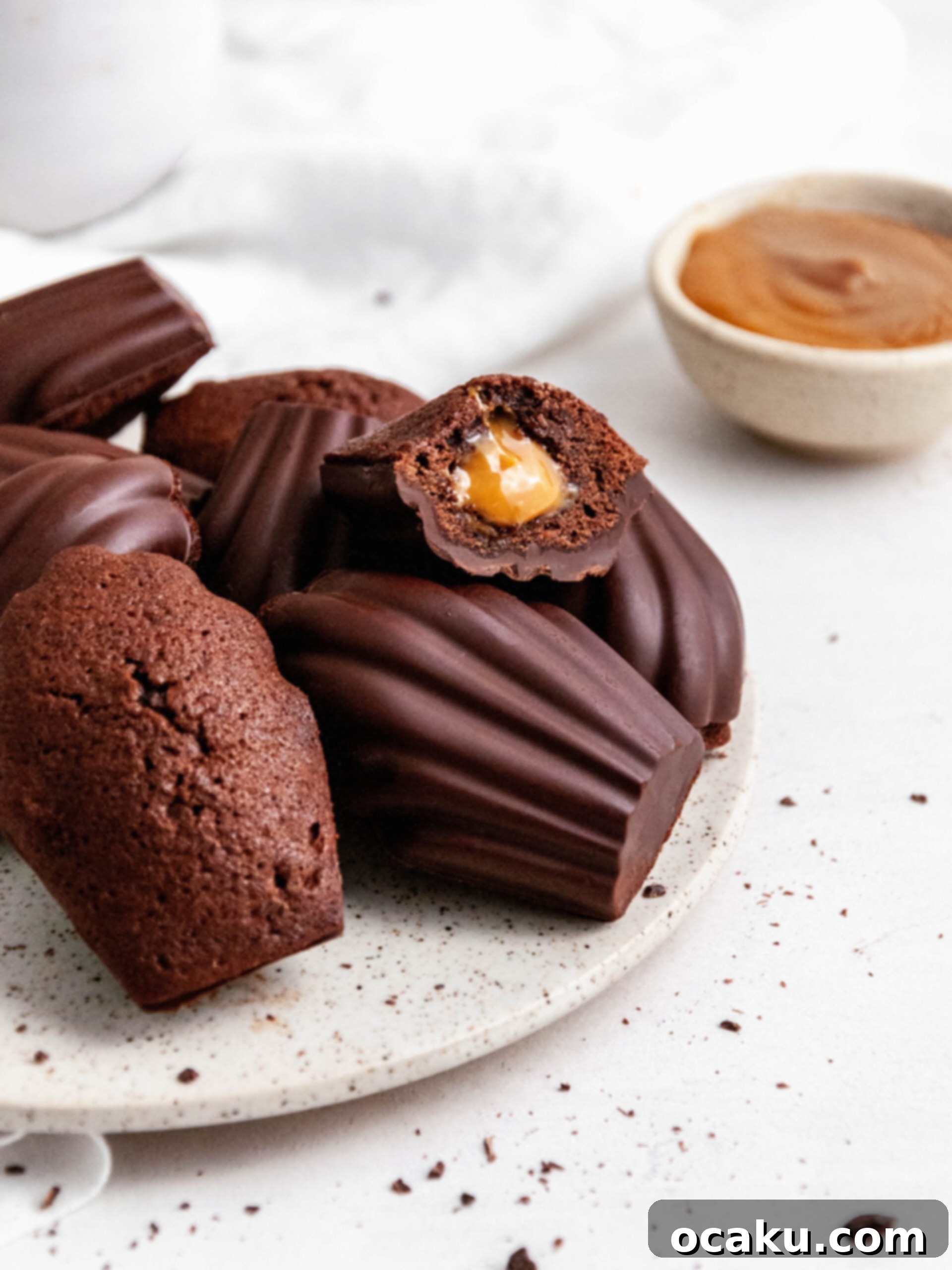 Decadent Chocolate Madeleines with Dulce de Leche 4 chocolate madeleines with Dulce de Leche on a plate, perfectly coated and ready to eat.