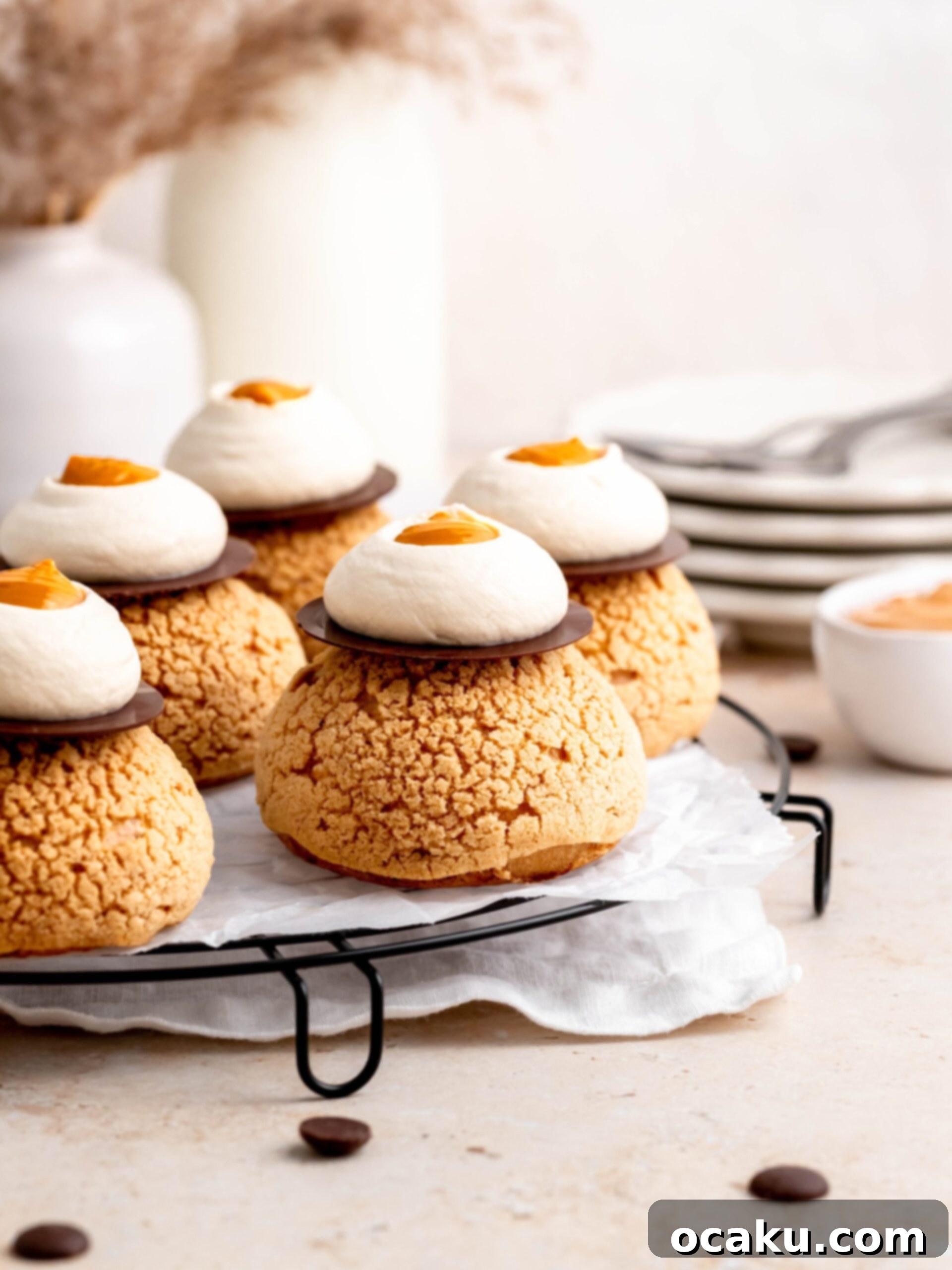 Close-up of Choux au Craquelin with Coffee and Salted Dulce de Leche on a tray, showing the perfect craquelin topping.