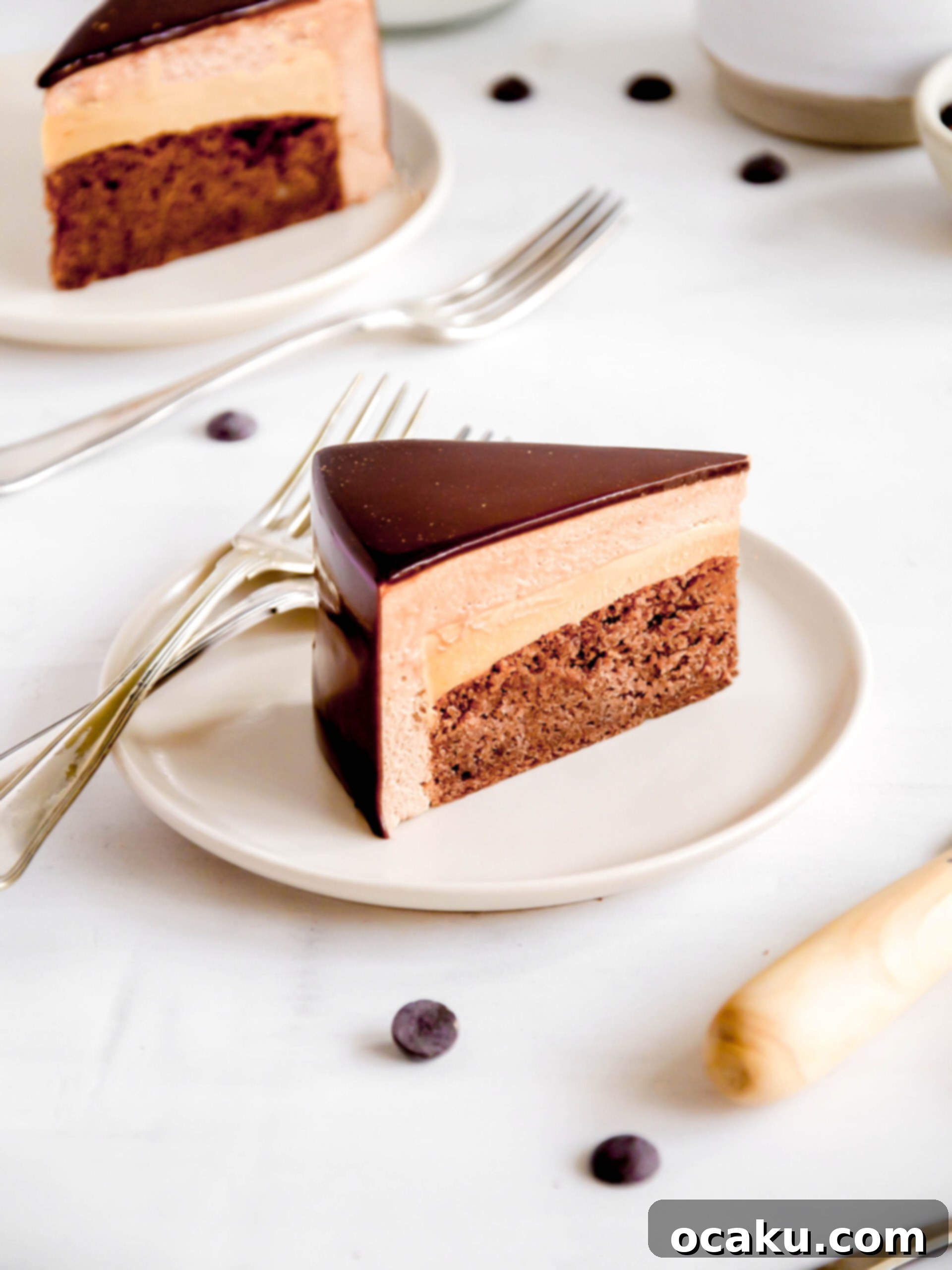 A delectable slice of chocolate and caramel mousse cake, revealing its beautiful layers, served elegantly on a plate.